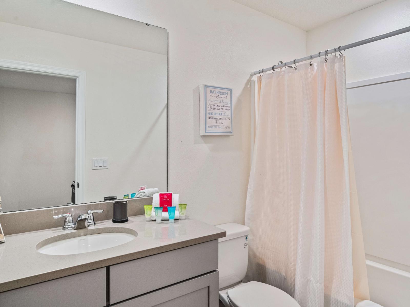 Polished Bathroom of the Townhouse in Kissimmee Florida - Bathtub and a shower combo - Sliding Curtain for added privacy - Chic vanity with large Mirror