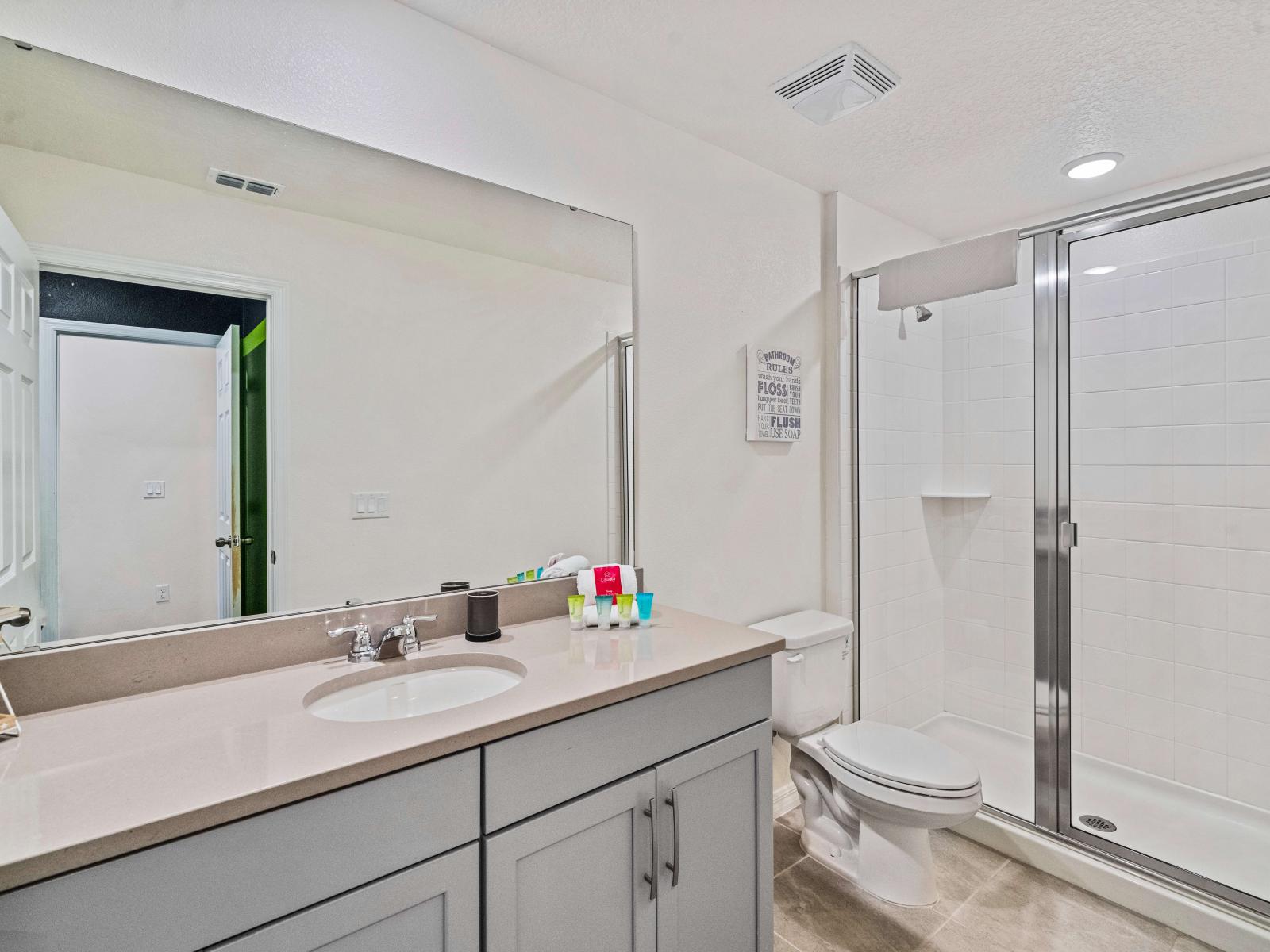 Lush Bathroom of the Townhouse in Kissimmee Florida - Glass enclosed shower area - Inviting bathroom with a soothing color palette for a tranquil feel - Attention to detail, from the elegant tiles to the faucets