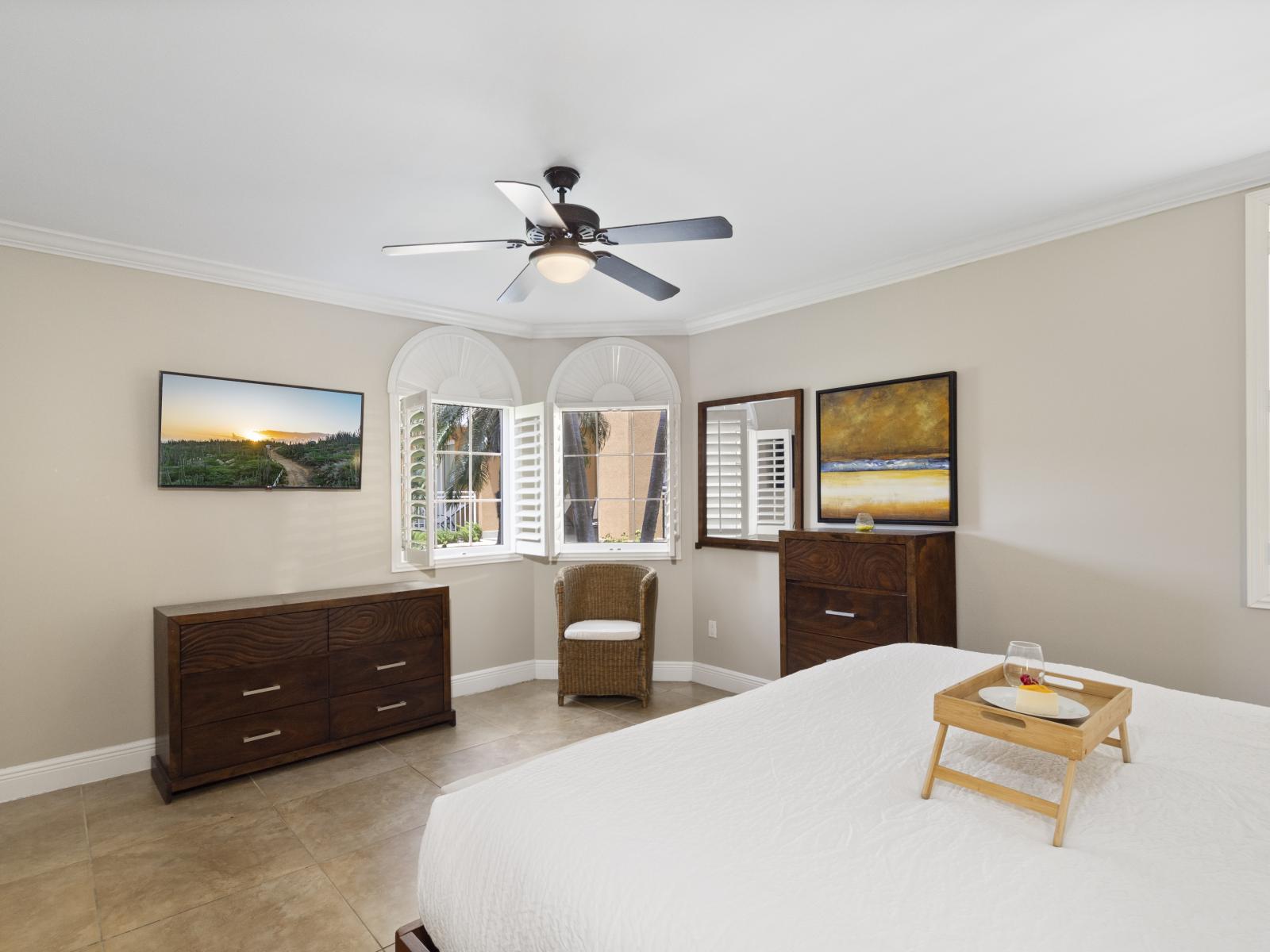 Relax in Bedroom 1, complete with a wall-mounted flat-screen smart TV for entertainment and relaxation.