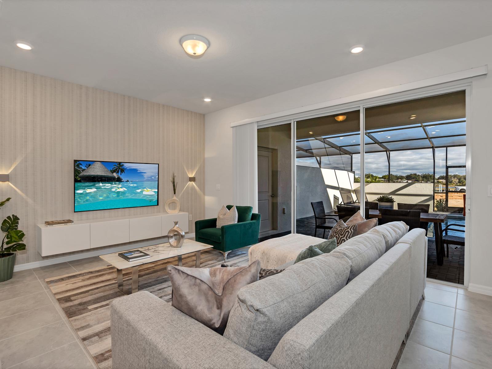 Well-Designed living area of the townhouse in Davenport Florida - Elegantly decorated with a neutral color palette for a timeless appeal - Easy access to outdoors with pool and seating - Cozy seating area conducive to relaxation and socializing