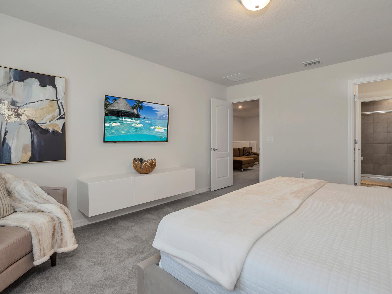 Inviting bedroom of the townhouse in Davenport Florida - Comfy double bed for restful nights - Attached bathroom for privacy and comfort - Smart TV and plush sofa for relaxation and entertainment