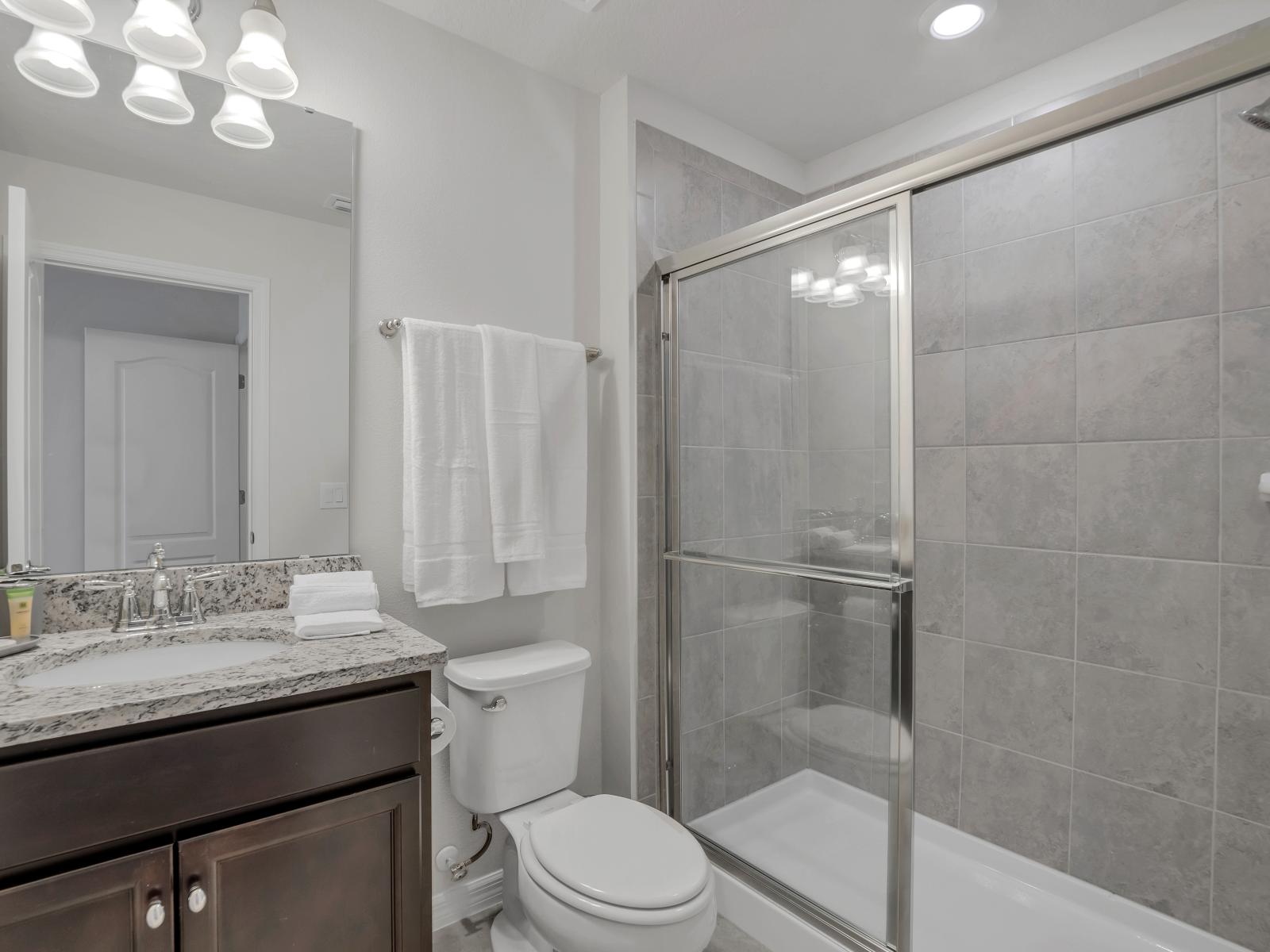 Captivating bathroom of the townhouse in Davenport Florida - Chic vanity with large mirror - Experience pure comfort - Featuring a spacious walk-in shower