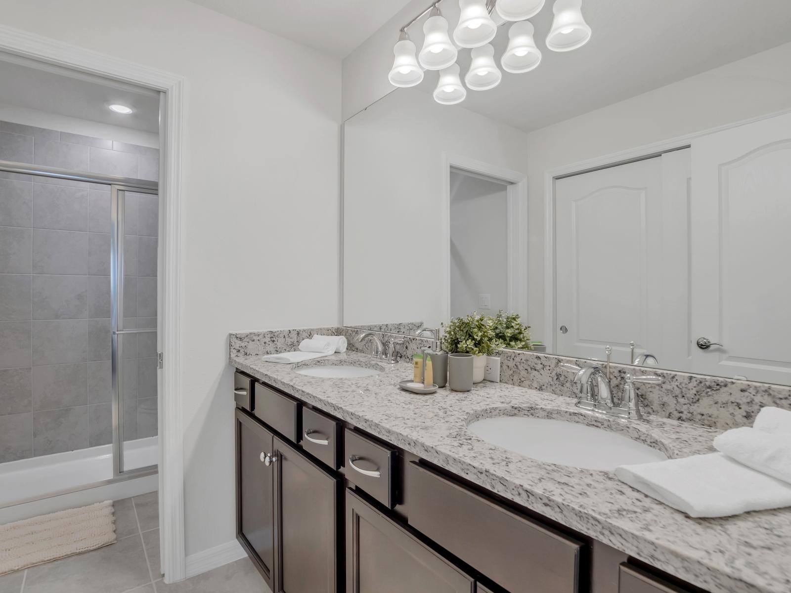 Polished bathroom of the townhouse in Davenport Florida - Spacious walk-in shower stall - Chic double vanity with upscale lighting and large mirror - Elegant bathroom with luxurious fixtures and finishes