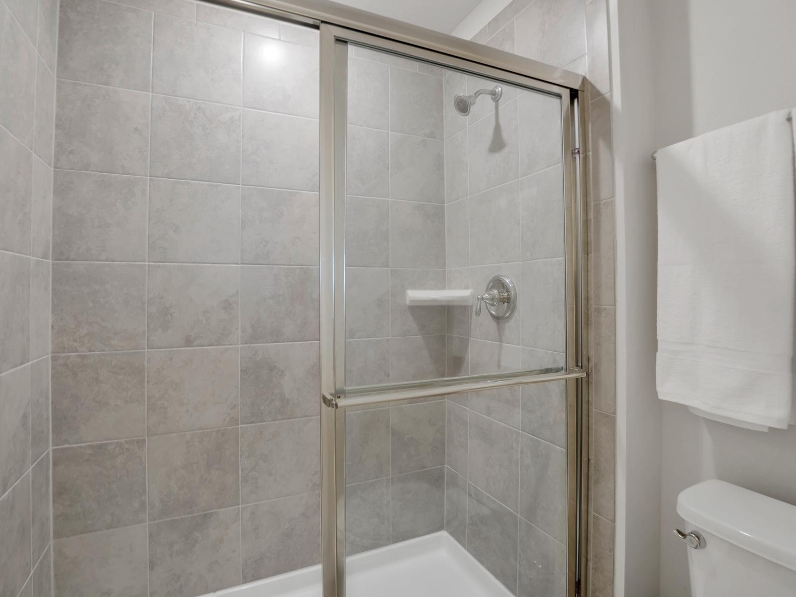 Tiled walk-in shower area of the townhouse in Davenport Florida - Spacious glass-enclosed stall to unwind - Availability of all bathroom amenities