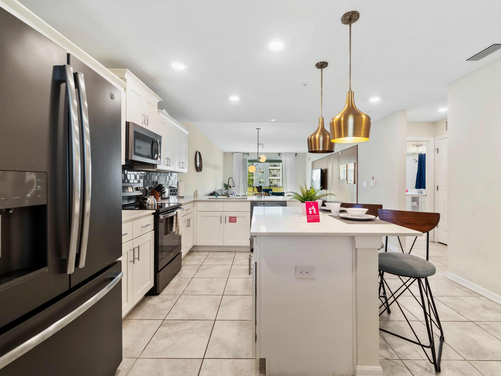 Modern kitchen of the Condo in Kissimmee Florida - Full equipped - Breakfast bar and high chairs - Featuring sleek, stainless steel appliances