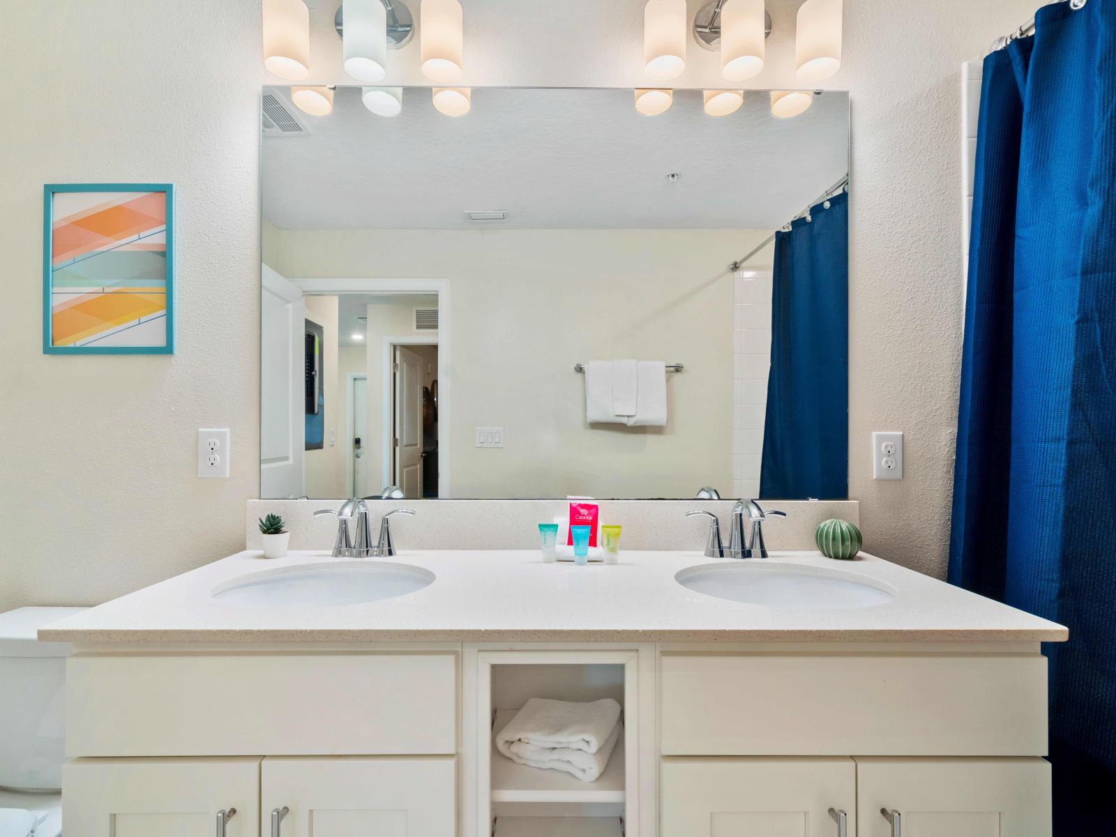 Upmarket Bathroom of the Condo in Kissimmee Florida - Bathtub and a shower combo - Chic double vanity with large mirror - Upscaled lighting