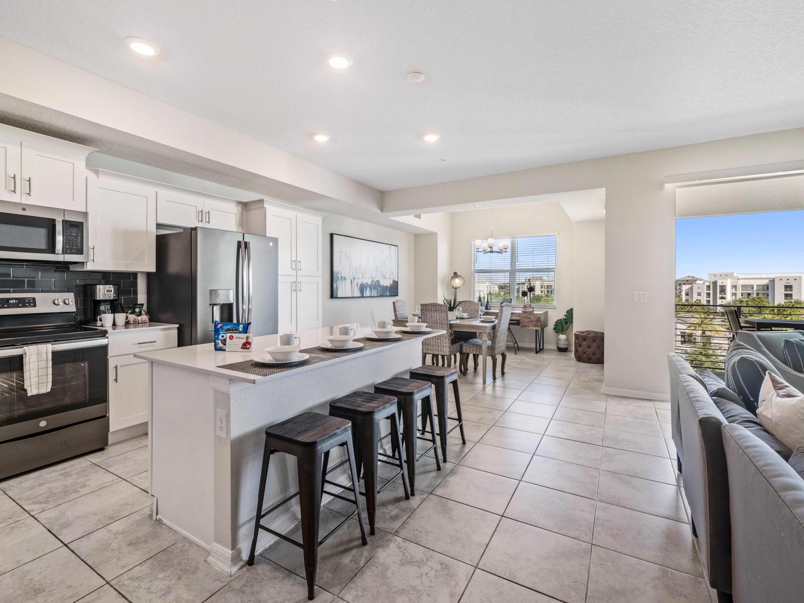 Spacious Fully Equipped Kitchen of the condo in Kissimmee - Availability of all necessary kitchen accessories - High Chairs available at the breakfast ar - Sufficient storage space to store goods - Balcony facing kitchen of the condo