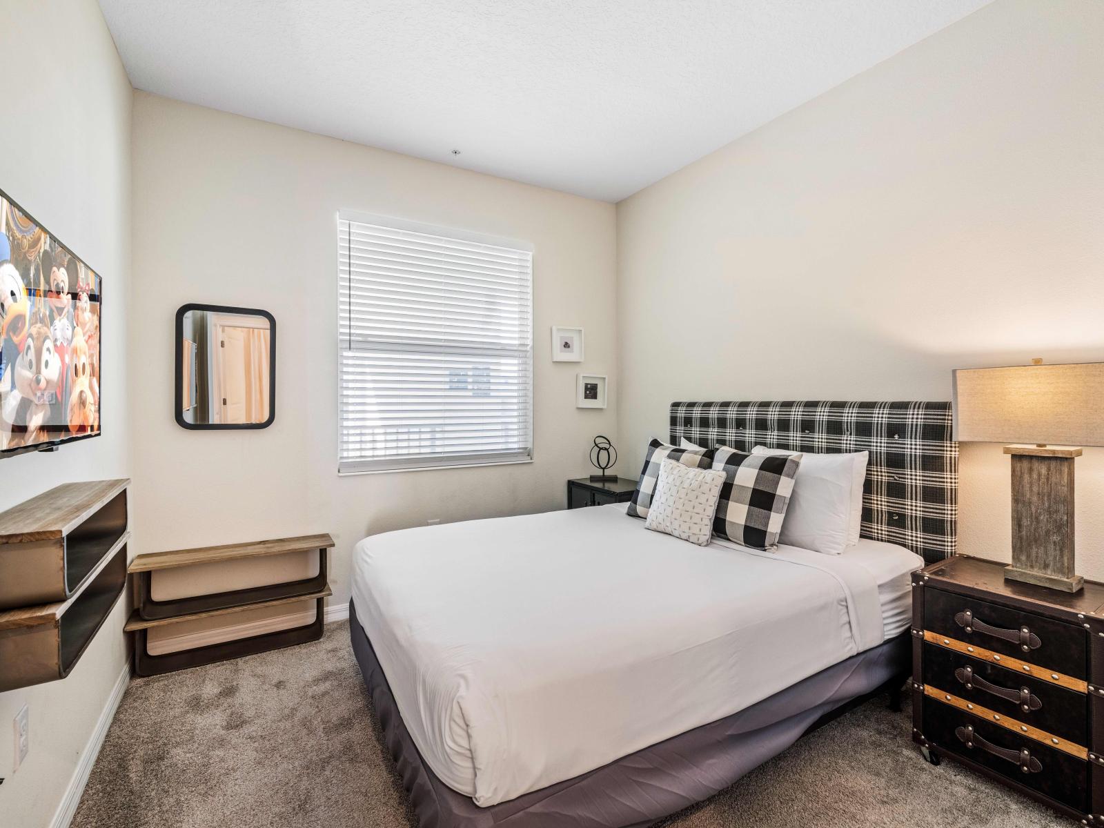 Luxurious Bedroom of the Condo in Kissimmee - Cozy bed  - Window with outside views - Majestic table lamps - Stunningly carpeted floor - Beautiful wall mirror and wall decored with aesthetic wall paintings - Availability of Smart TV and Netflix