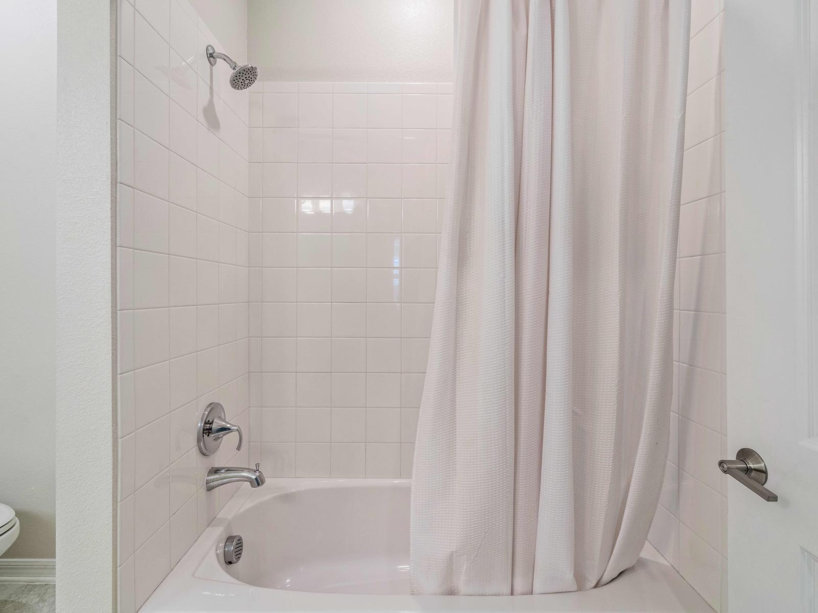 Glamorous Bathroom of the condo in Kissimmee - All  Bathroom amenities available - Neat and clean Toilet seat - Cozy bath and shower area with sliding curtain - Beautifully tiled washroom