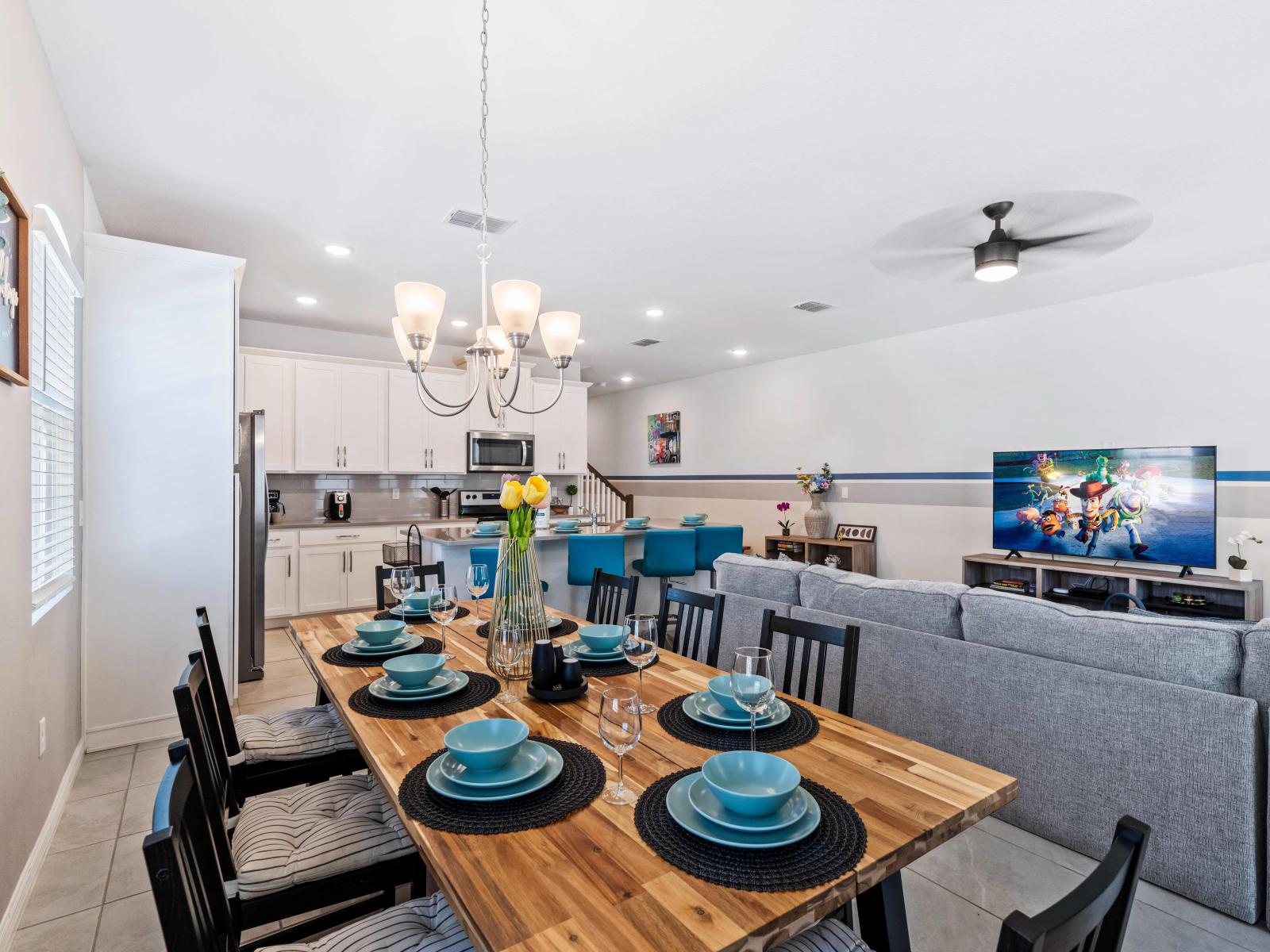 Experience the opulent dining area in Kissimmee, featuring an impressive 8-seater table - Majestically adorned with a chandelier and thoughtfully designed  - The lavish space, illuminated by elegant lighting offers a picturesque setting