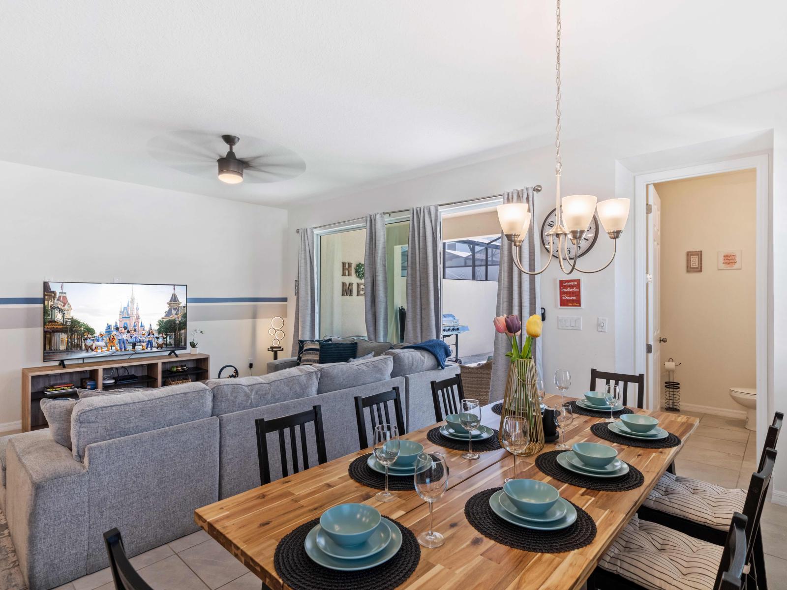 Gather around the table in our welcoming dining area of the home in Kissimmee - Experience our 8 persons dining area enhanced by soft lighting, charming décor, and a cozy ambiance. - Offering a spacious and warm environment for quality time.