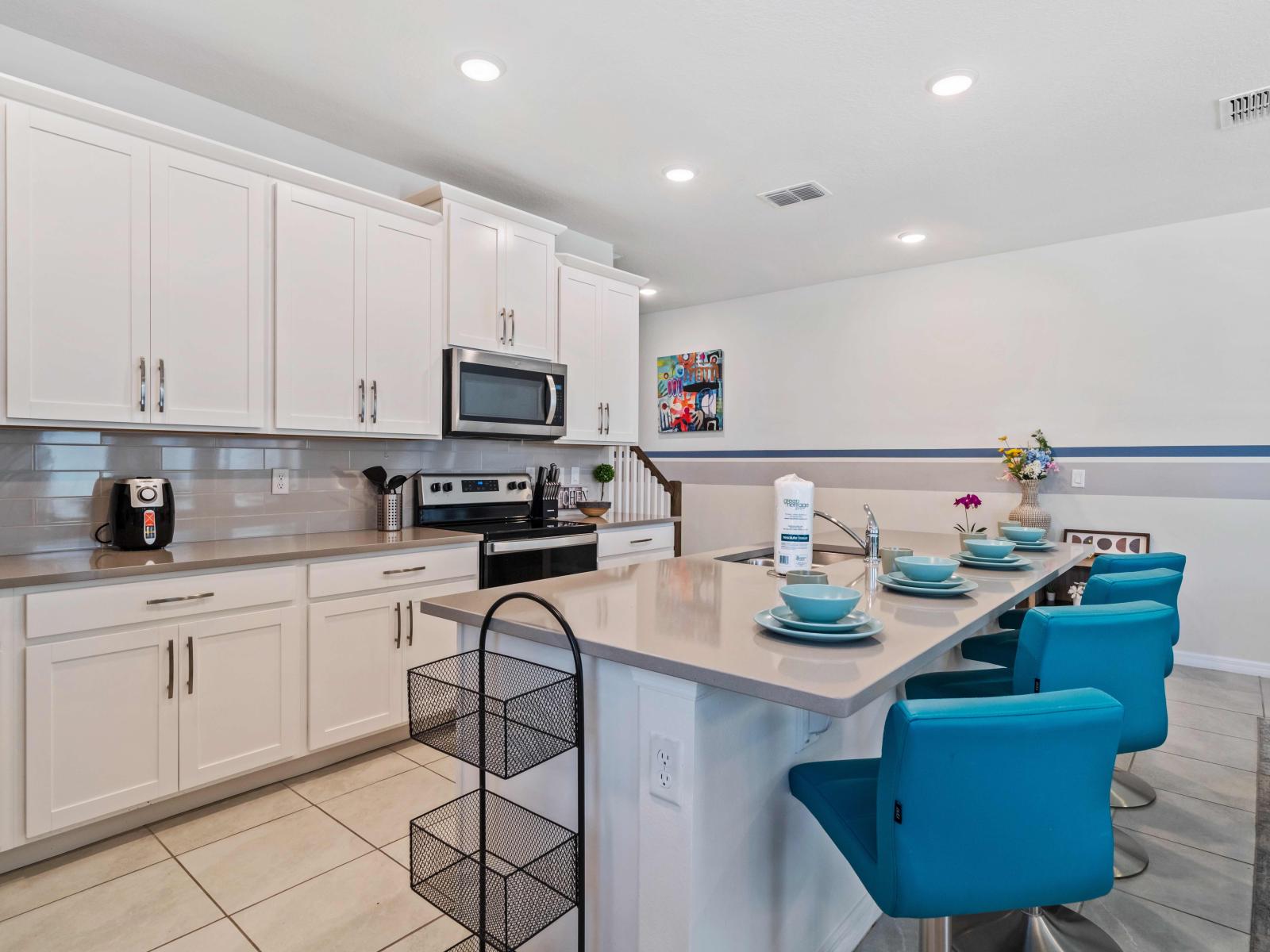 Gloriously designed and Full equipped kitchen of the home at Kissimmee - Sufficient space to store goods and work according to your ease - Availability of all kitchen accessories - availability of high chars at the breakfast bar - Elegant lighting