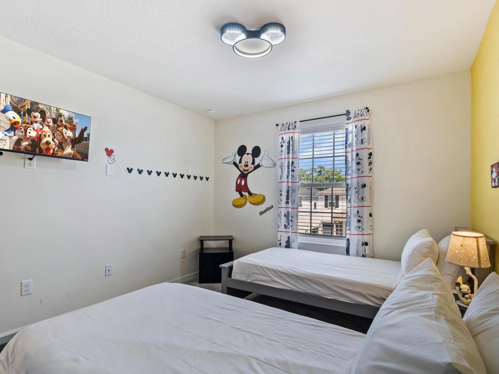 Immerse yourself in the enchanting Disney world through the Mickey Mouse-themed bedroom at Vista Cay Resort - Featuring captivating décor and two single beds for relaxation - This room invites you to relive your childhood dreams.