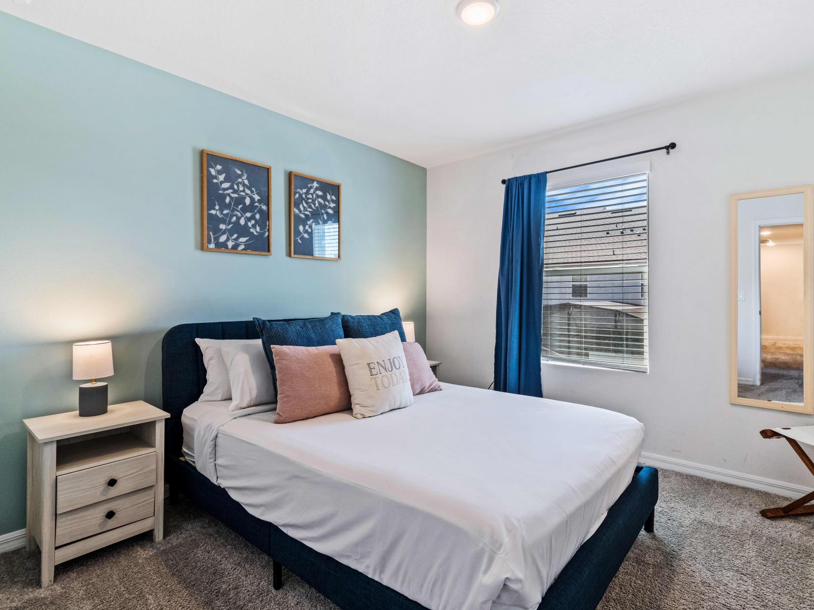 Well-appointed Bedroom of the home in Kissimmee - With a king size bed with neat and clean linen - Elegantly carpeted floor - Majestic decor with wall paintings and table lamps - Gloriously placed wall mirror - Well located bedside window