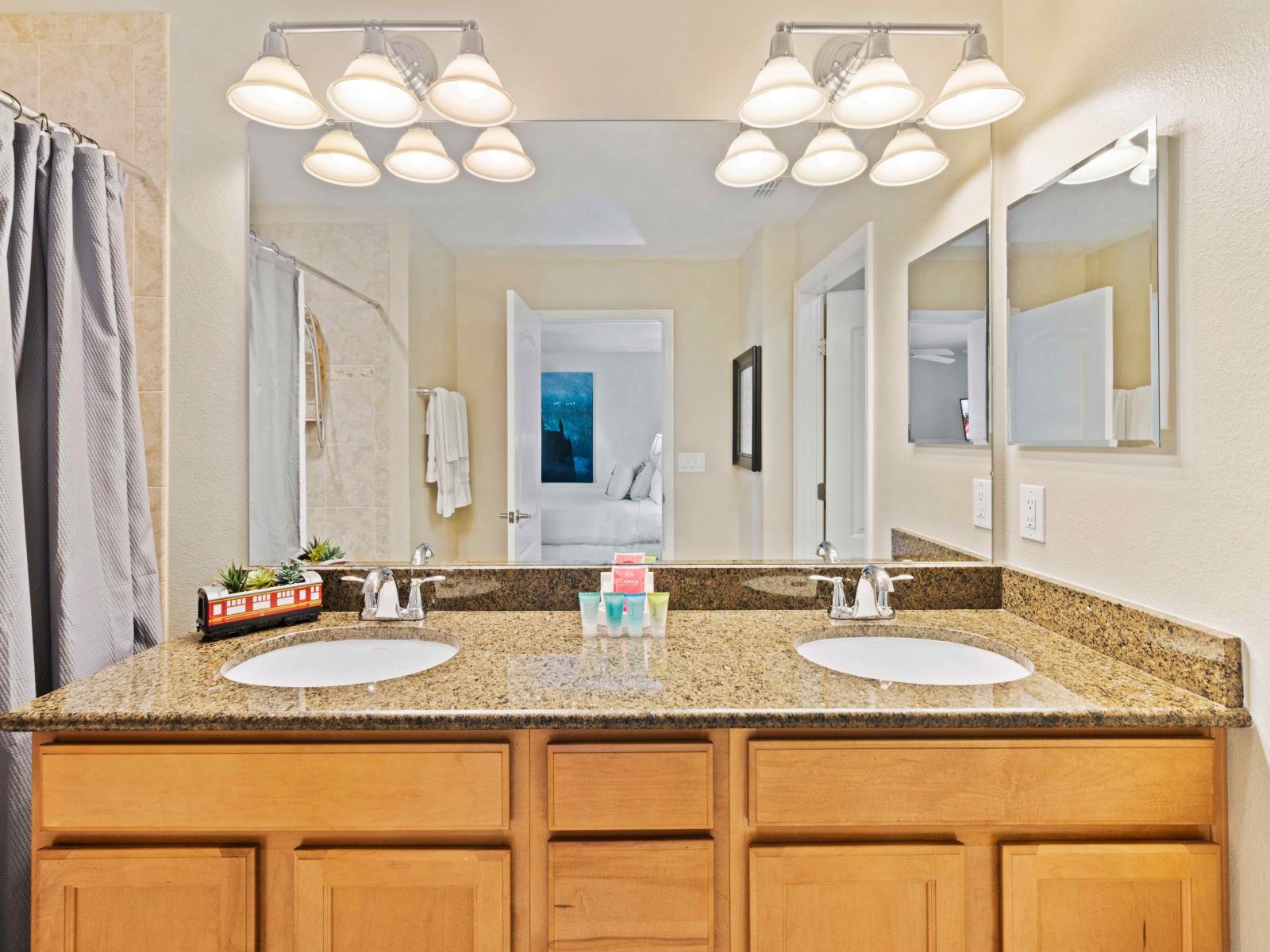 Stylish Bathroom of the Townhouse in Kissimmee Florida - Offering glass-enclosed walk-in shower  - Chic dual vanity with large mirror - Thoughtful storage solutions with stylish cabinets