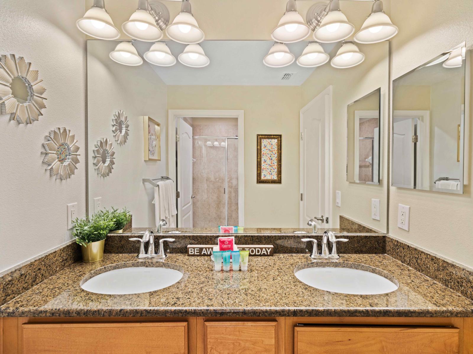 Stylish Bathroom of the Townhouse in Kissimmee Florida - Offering glass-enclosed walk-in shower  - Chic dual vanity with large mirror - Thoughtful storage solutions with stylish cabinets