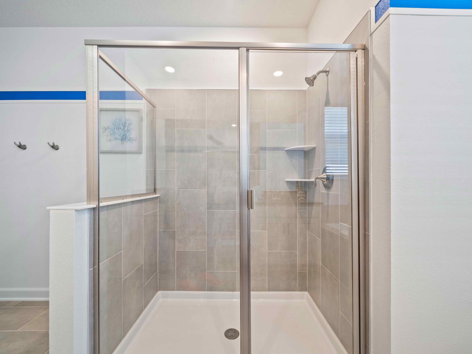 Glass enclosed shower area of the Bathroom of the home in Davenport - Sophisticated color palette creating a serene ambiance - Elegant bathroom with luxurious fixtures and finishes