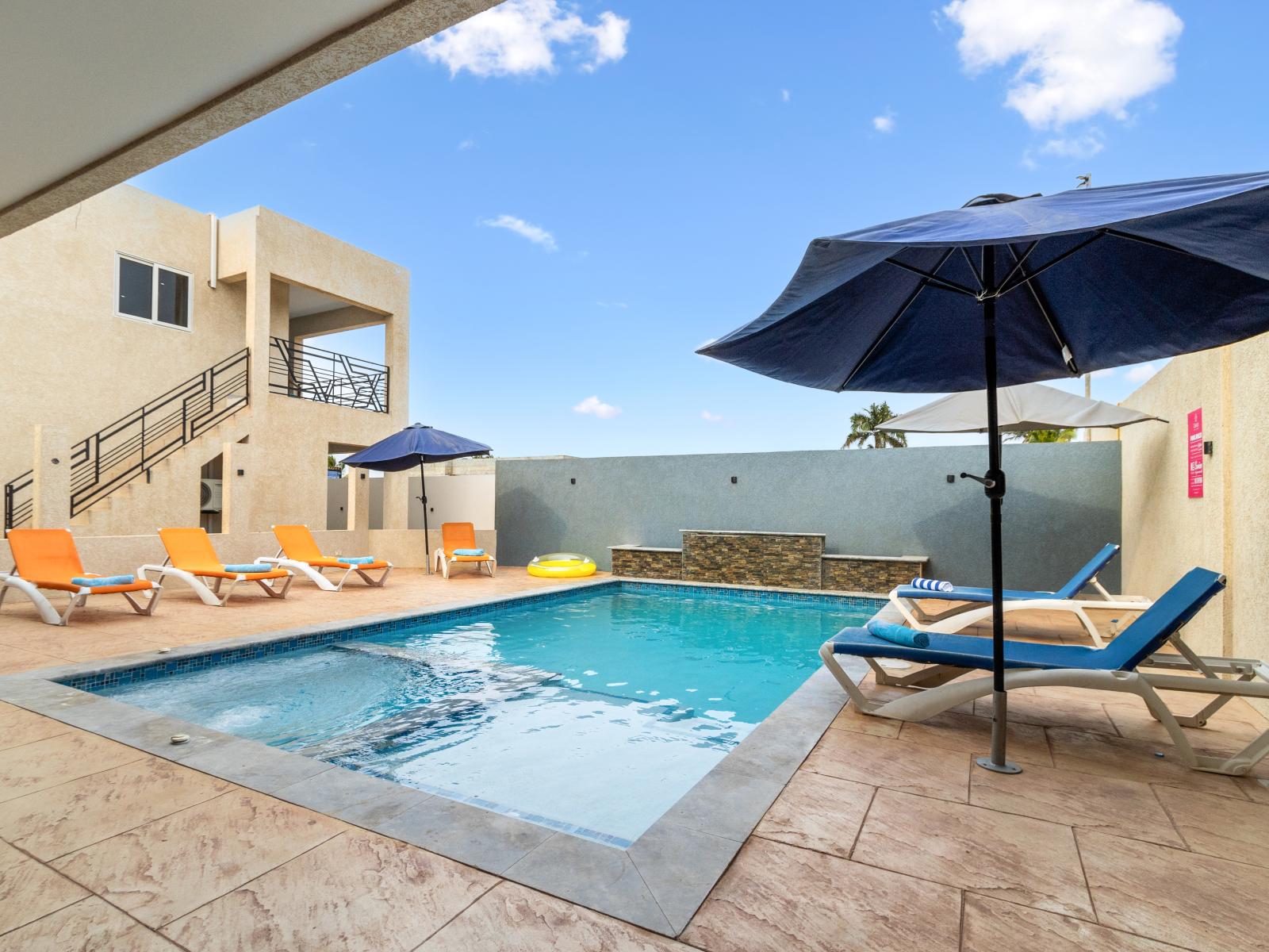 Charming shared pool area of the apartment in Oranjestad Aruba - Lounge chairs and a heated jacuzzi - Relax by the shimmering poolside oasis - Dive into a refreshing poolside escape