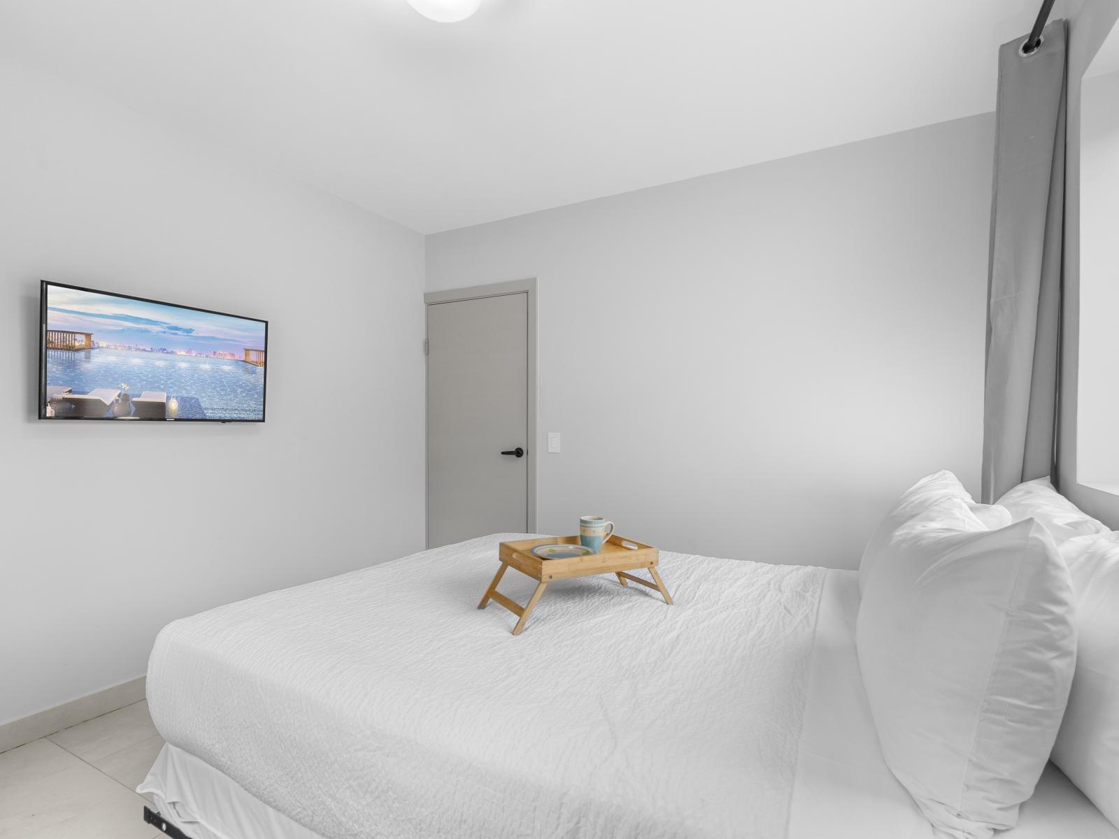 Relaxing bedroom of the apartment in Oranjestad Aruba - Features a wall mounted flat screen smart TV for entertainment - Thoughtfully designed bedroom featuring functional and stylish furniture - Plush bedding and pillows with queen size bed