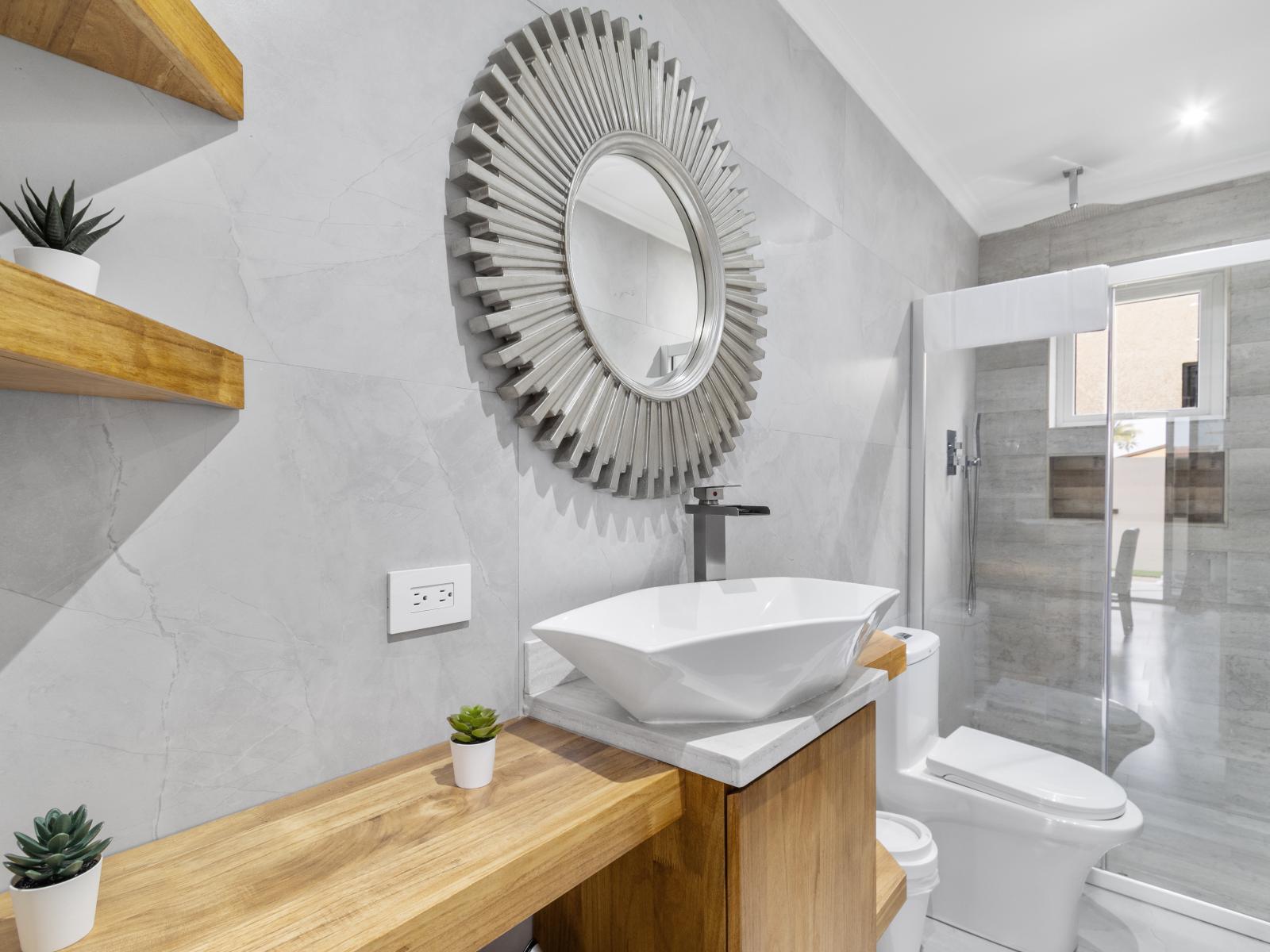 Lofty bathroom of the apartment in Oranjestad Aruba - Glass enclosed walk-in shower stall - Effortlessly stylish with a freestanding vanity and chic accessories - Functional yet glamorous, with thoughtfully chosen fixtures