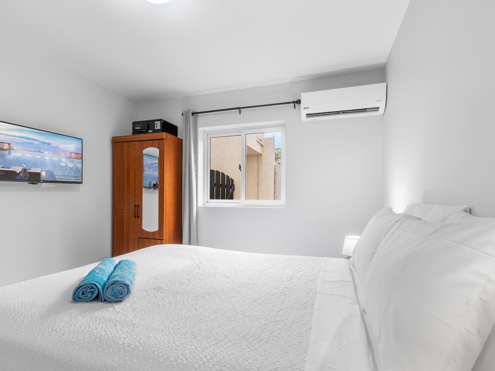 Enchanting bedroom of the apartment in Oranjestad Aruba - Wall mounted smart TV - Comfy double bed for restful nights - Well-appointed bedroom with neutral tones for a calming atmosphere