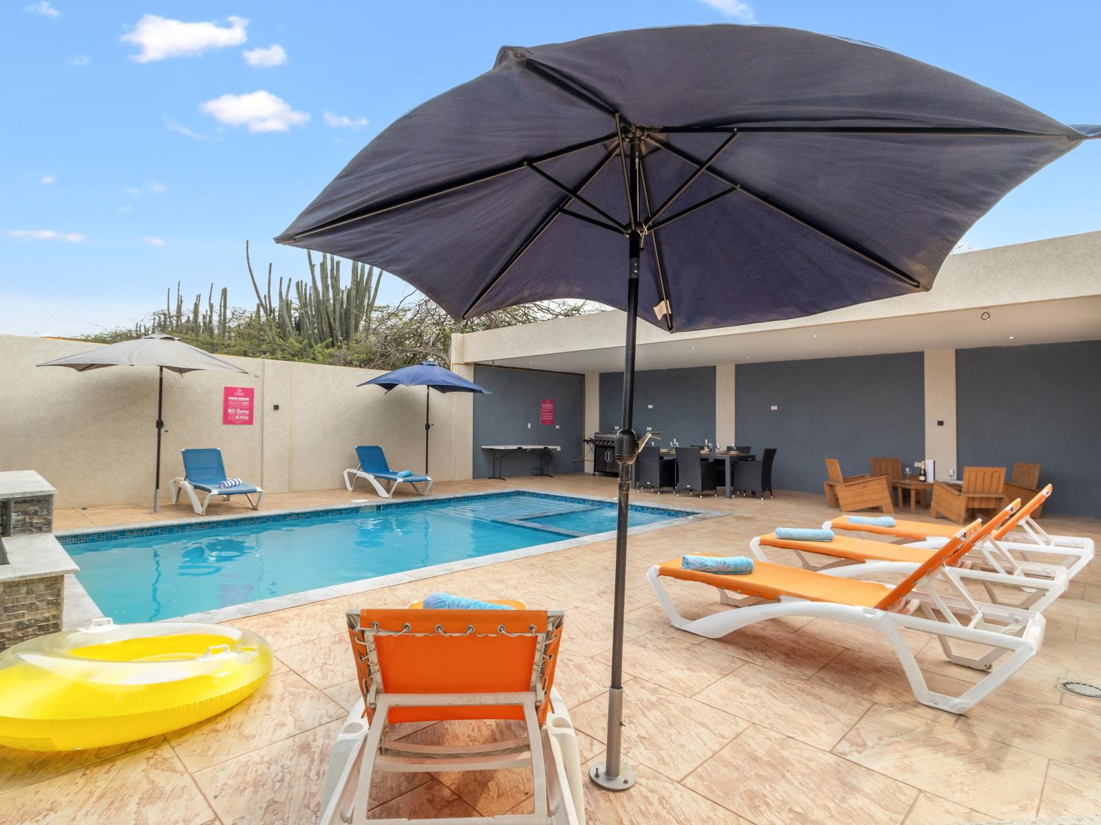 Refreshing shared pool area of the apartment in Oranjestad Aruba - Floating tube - Comfortable seating areas for enjoying cocktails with friends - A tranquil retreat where you can indulge in relaxation