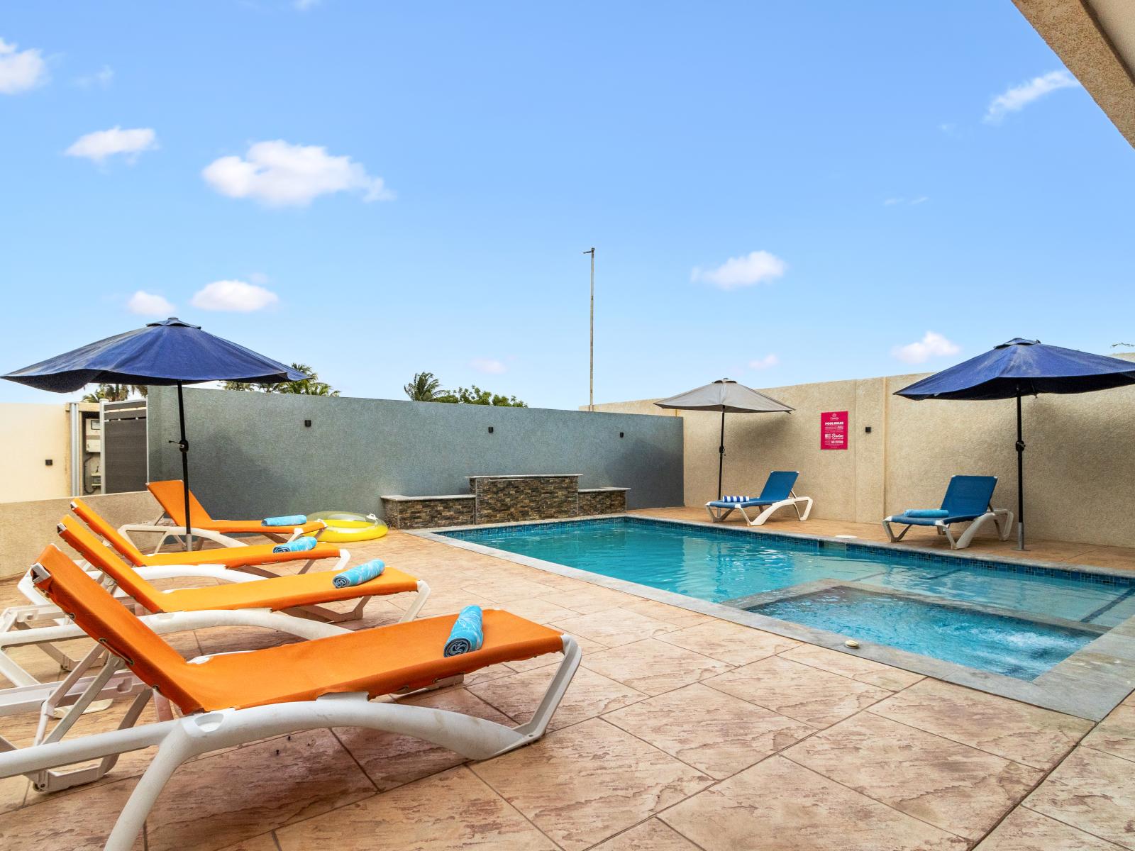 shared pool area of the apartment in Oranjestad Aruba - Lots of chairs by the pool for laying in the sun - Glistening waters inviting you to take a refreshing swim