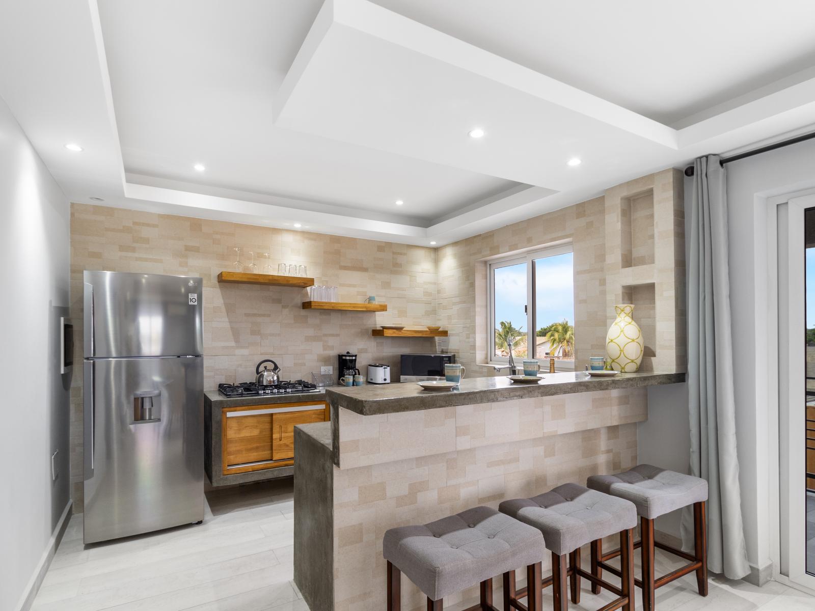 Beautiful kitchen of the apartment in Oranjestad Aruba - Modern kitchen with stainless steel appliances - Breakfast bar and high chairs - Thoughtful placement of kitchen essentials for easy access