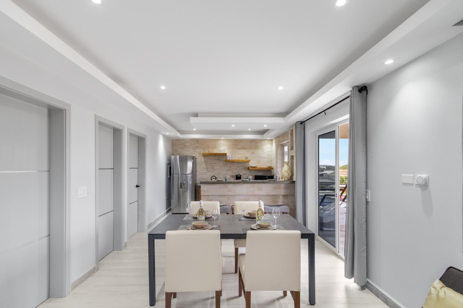 Dining area and kitchen of the apartment in Oranjestad Aruba - Sophisticated design with a blend of modern and classic elements - Open layout seamlessly connecting the dining area to the kitchen - Easy outdoor access