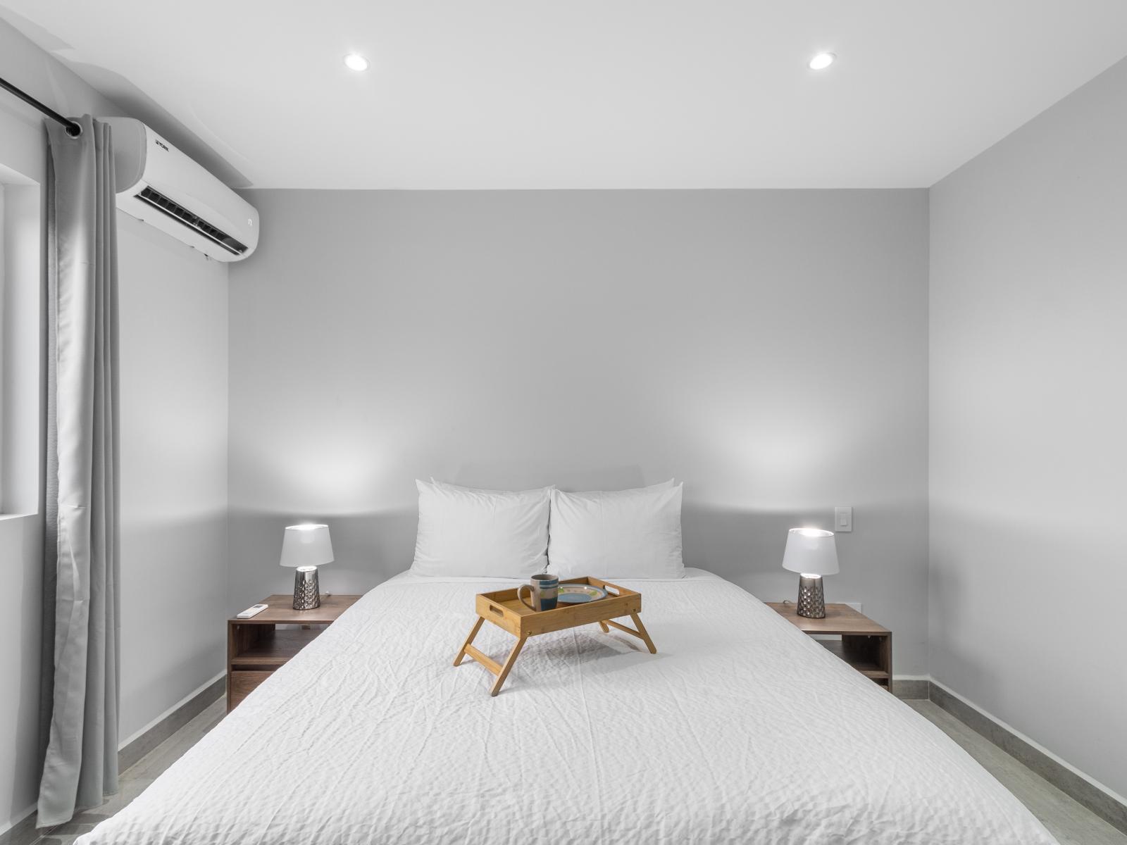 Calming bedroom of the apartment in Oranjestad Aruba - Features a queen size bed for comfort - Minimalist decor, creating a clean and uncluttered sleeping space - Attached bathroom for privacy