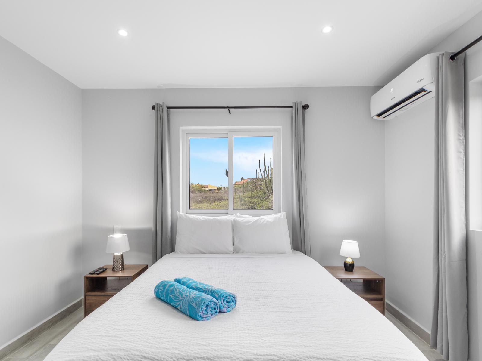 Inviting bedroom of the apartment in Oranjestad Aruba - Luxurious bedding for a restful night's sleep - Modern bedroom with sleek design and plenty of natural light - Harmonious color palette creating a soothing atmosphere