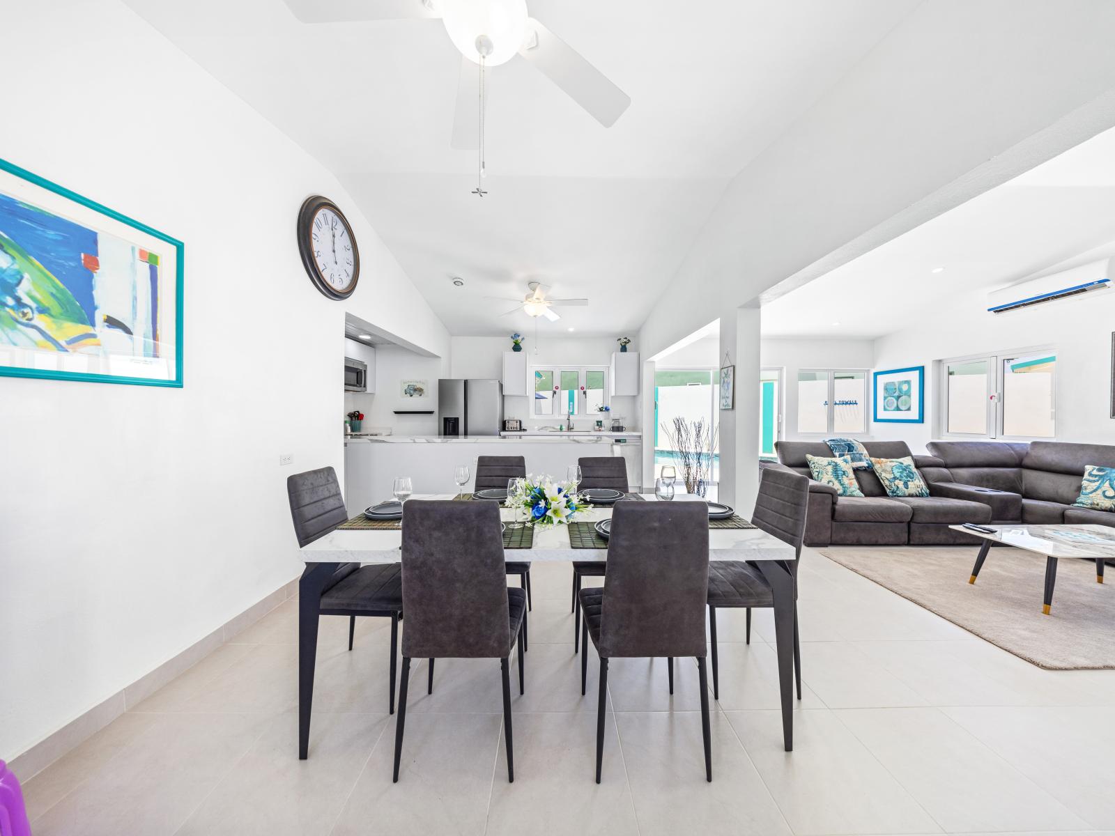 - Enjoy memorable family dinners around a stylish dining table in an open-concept space - Seamless flow from the dining area to the cozy living room makes entertaining a breeze - Elegant decor and contemporary artwork enhance the inviting atmosphere