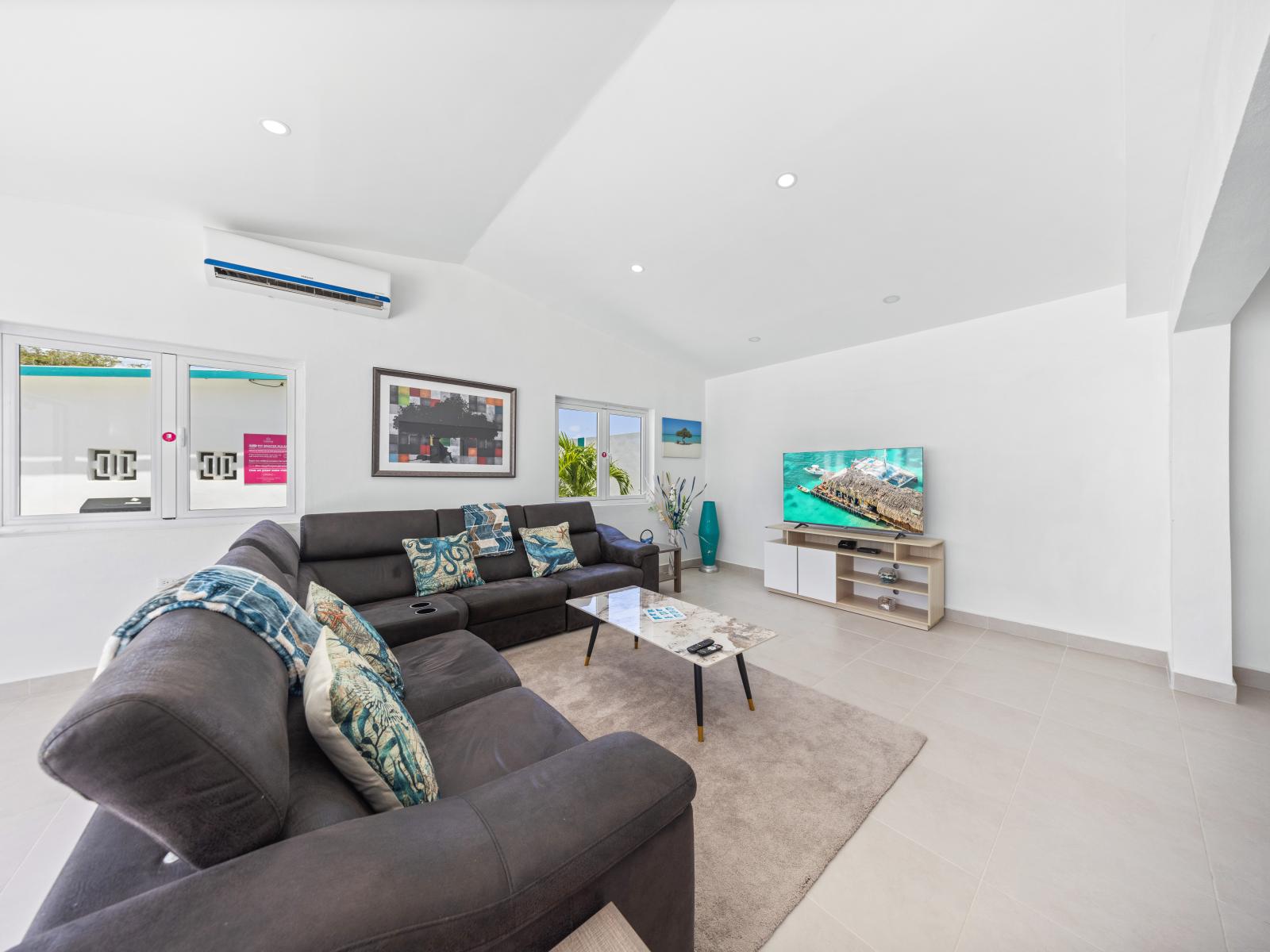 - Relax in a spacious living room with a plush sectional sofa, perfect for movie nights - Large windows let in natural light, creating a bright and airy atmosphere throughout the day - Smart TV and modern decor complete the stylish, comfortable space