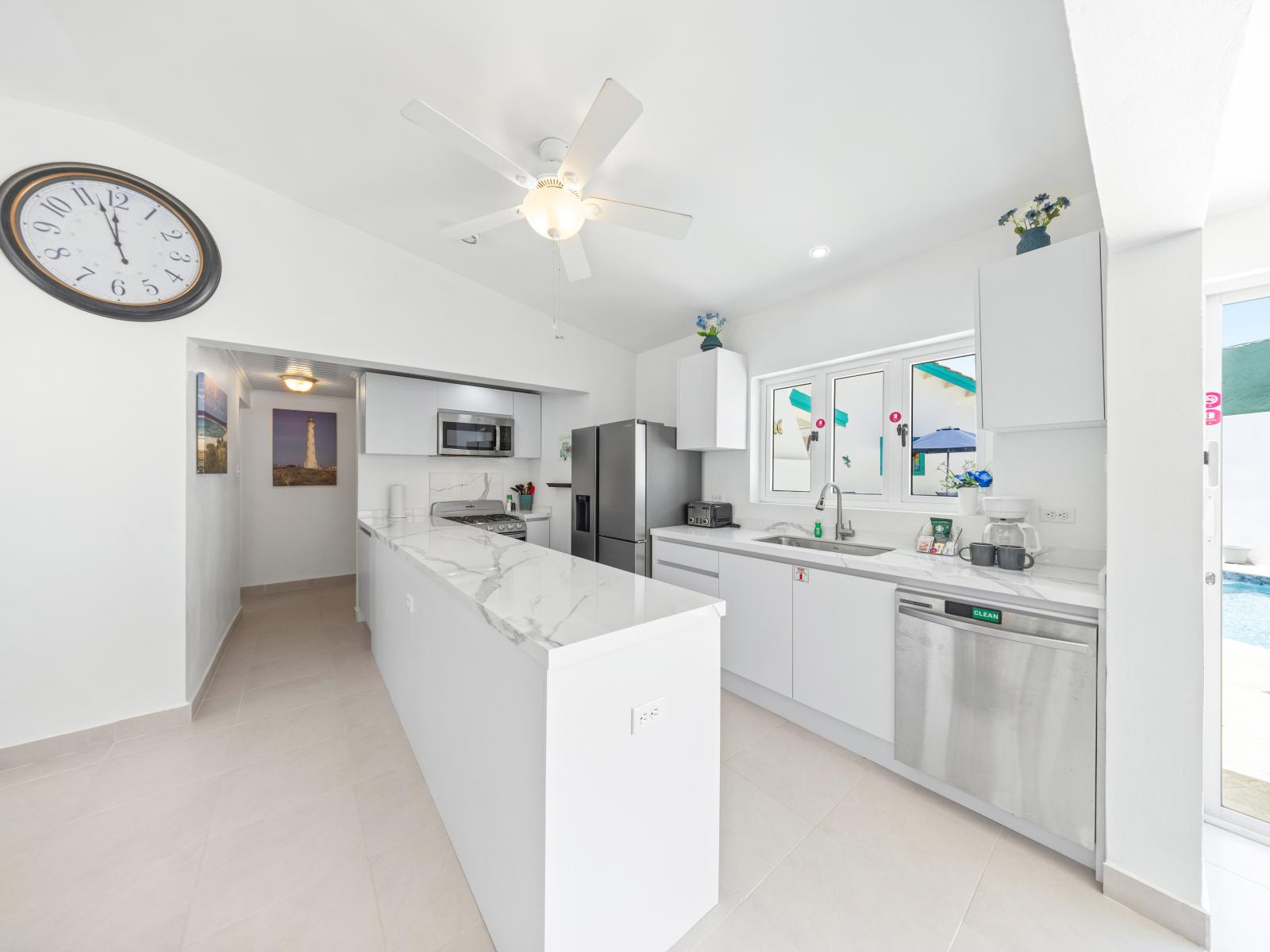 - Bright and spacious kitchen with modern appliances, perfect for whipping up a gourmet meal - Elegant marble countertops provide plenty of space for food preparation and presentation - Enjoy cooking with a poolside view through large, sunlit windows