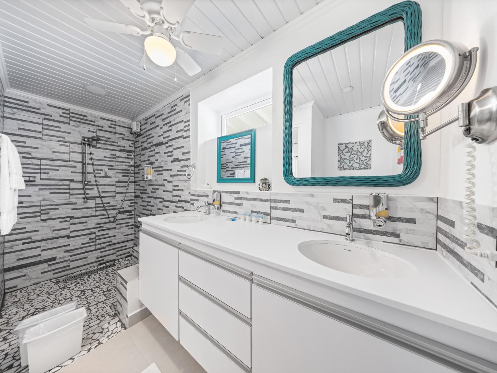 - Modern bathroom with sleek, stylish tile work and a spacious walk-in shower - Enjoy the convenience of dual sinks, perfect for couples to get ready simultaneously without hassle - Bright, airy feel enhanced by natural light and a large mirror