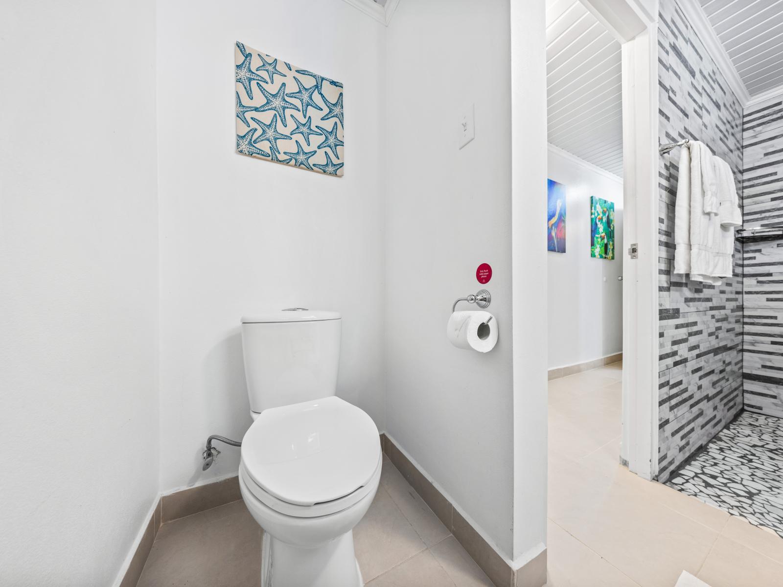 - Bright, pristine toilet area that offers both privacy and convenience - Strategically located for easy access, blending seamlessly with the bathroom’s modern design - Adorned with playful starfish artwork, adding a splash of coastal charm