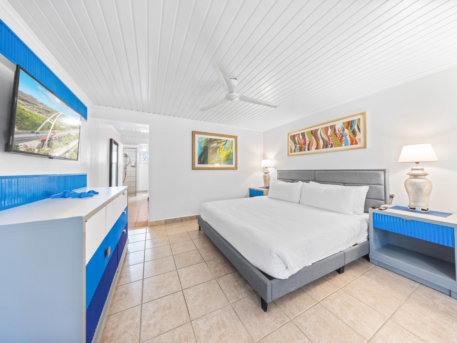 - Unwind in this serene bedroom with a comfortable king-sized bed - Enjoy entertainment on the wall-mounted TV after a day of adventure - The vibrant decor adds a touch of flair, ensuring your stay is both comfortable and visually inspiring