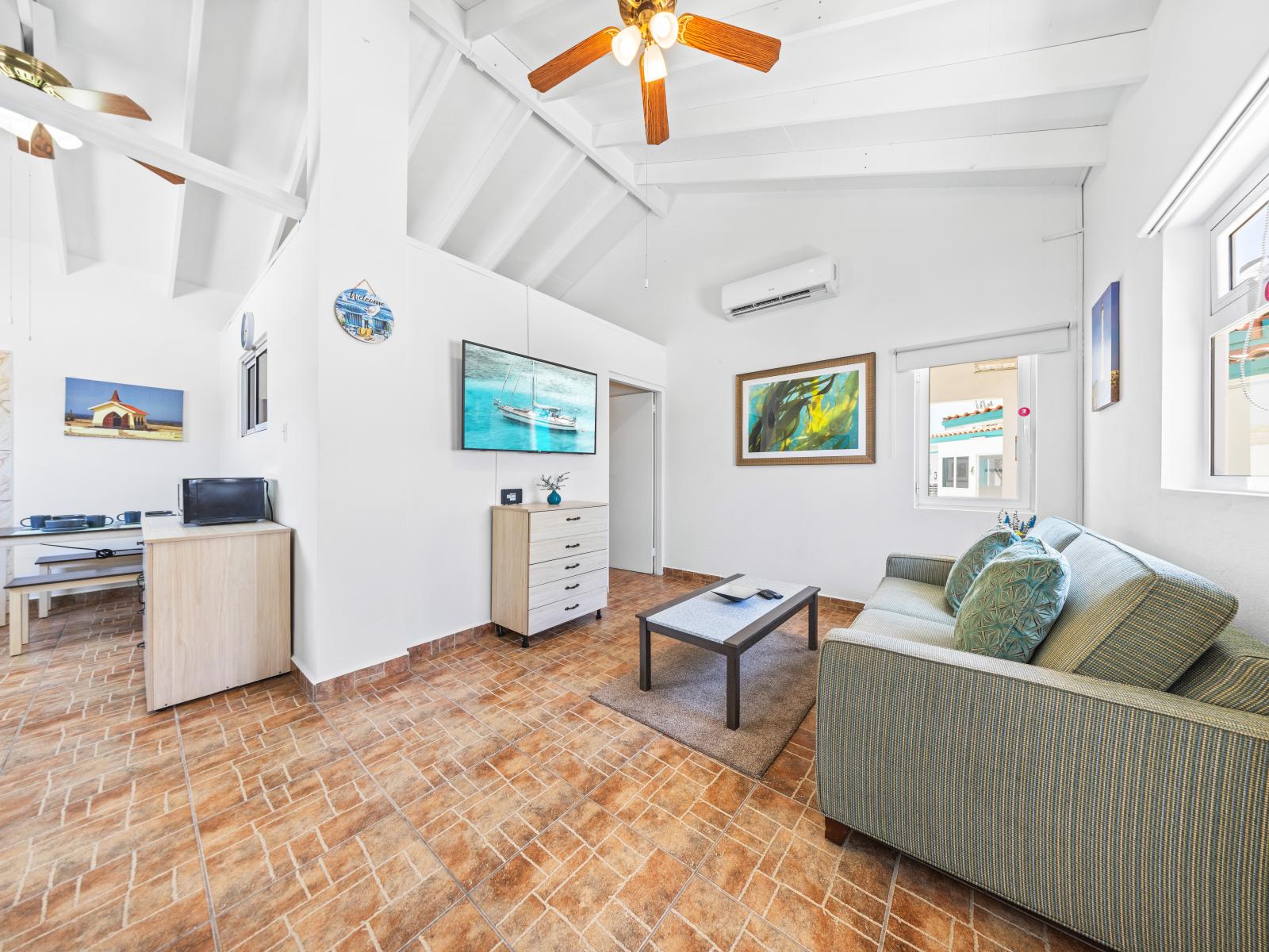 - Spacious living area with high ceilings and a ceiling fan, perfect for keeping cool in tropical weather - Enjoy your favorite shows on the flat-screen TV in a bright environment - Comfortable seating invites you to relax after a day of exploring