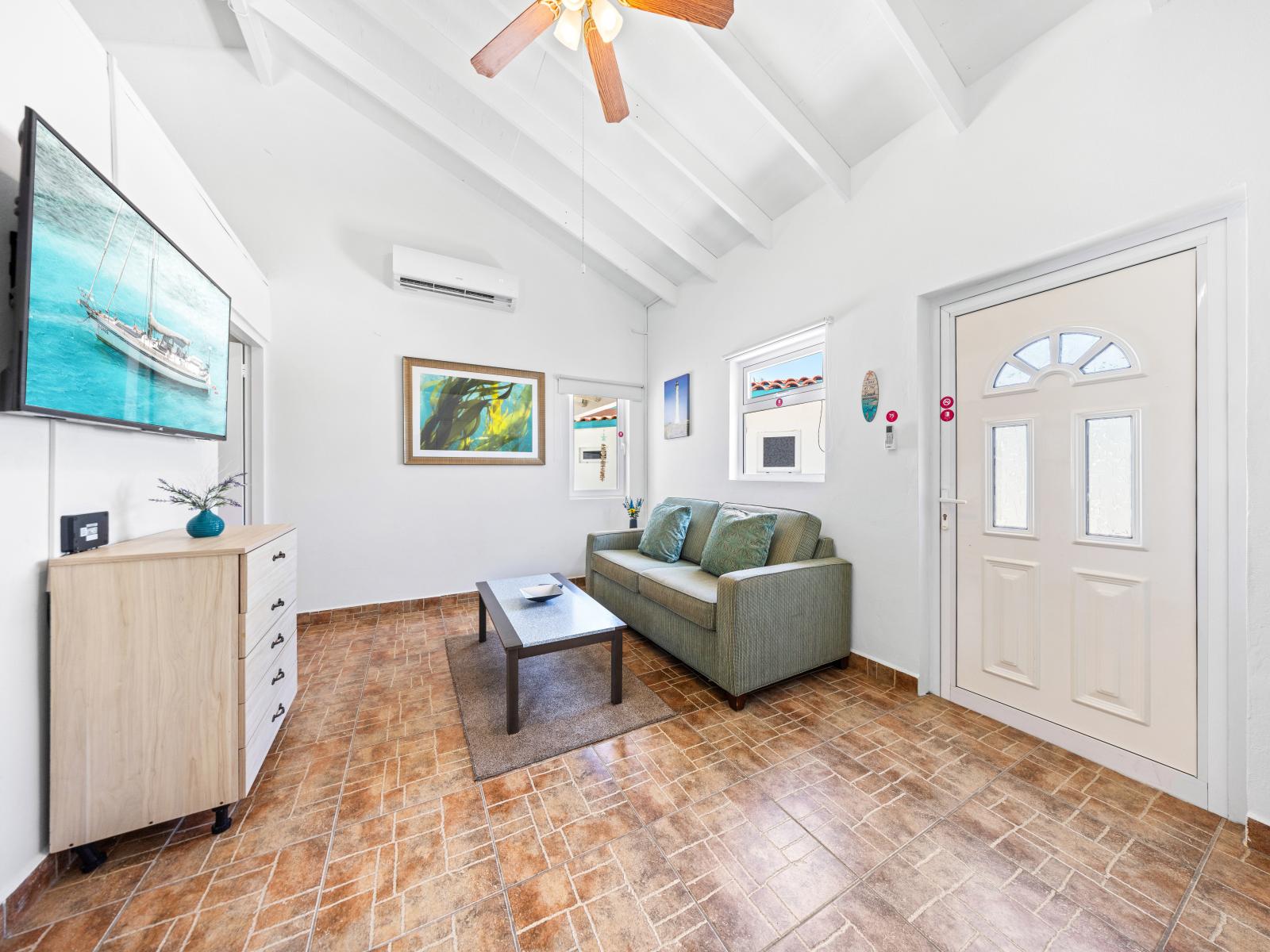 - Step into this sunlit living area, where vaulted ceilings create an open, airy feel - Kick back on the cozy sofa and lose yourself in a movie on the flat-screen TV - Enjoy perfect comfort with a ceiling fan and air conditioning to keep you cool