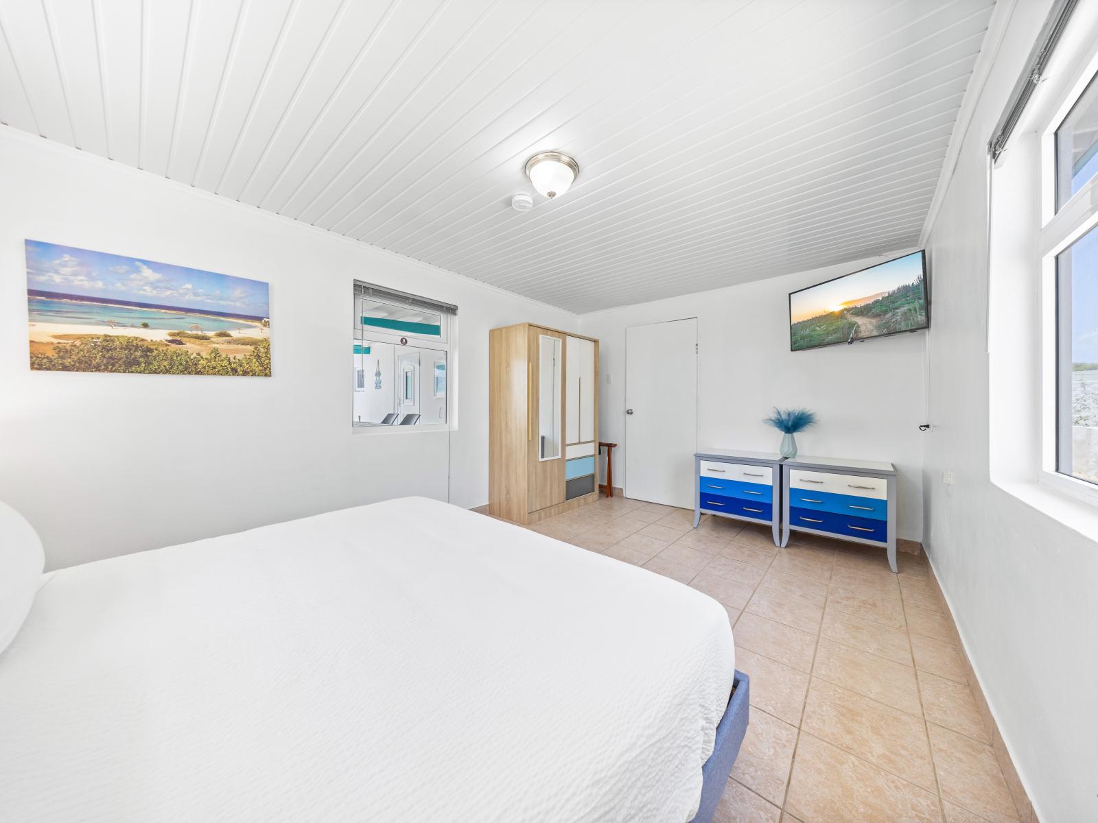 - Bright and airy bedroom with large windows that let in plenty of natural light - Comfortable king-size bed with fresh linens for a relaxing stay - Stylish decor and modern amenities, including a flat-screen TV, for your convenience