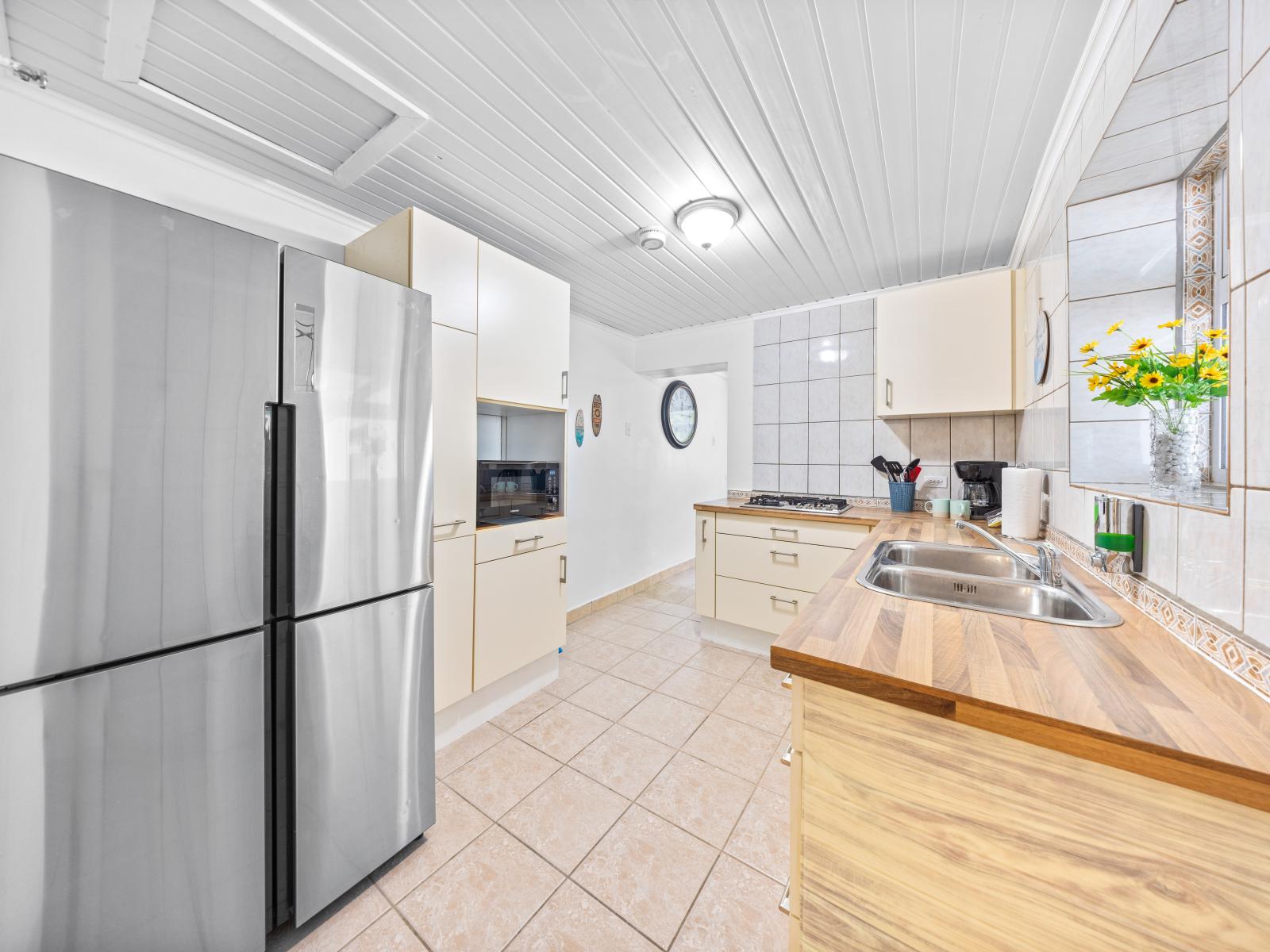 - Spacious kitchen equipped with modern stainless steel appliances for your culinary needs - Plenty counter space, perfect for meal preparation or enjoying a casual breakfast - Bright atmosphere, enhanced by natural light and charming floral accents