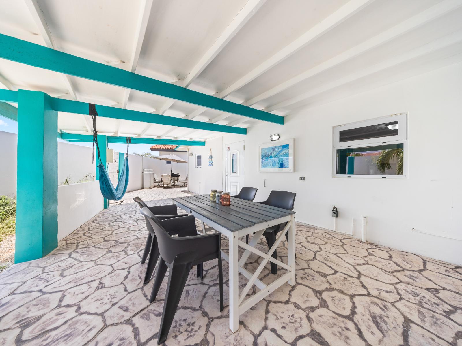 - Enjoy outdoor dining in the shade with a view of the serene patio area - Relax in the hammock and let the gentle breeze lull you into a peaceful nap - This covered space is perfect for meals, games, or simply unwinding with friends and family