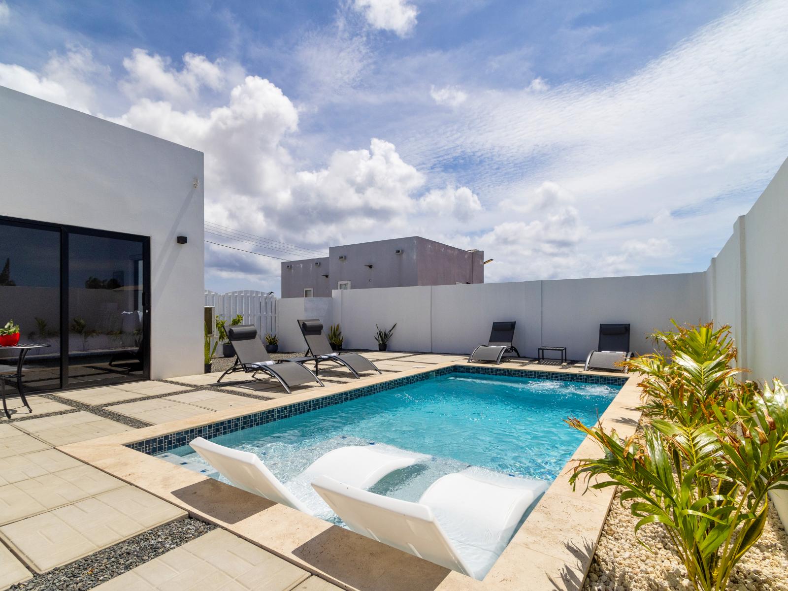 Refreshing private pool of the home in Oranjested Aruba - Relax by the shimmering poolside oasis - Bask in sun-kissed luxury near the water - Dive into a refreshing poolside escape - Modern lounge chairs for relaxation