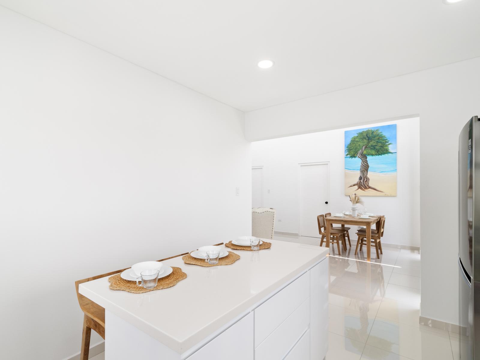 Modern kitchen of the home in Oranjested Aruba - Breakfast bar and High chairs - Open concept connecting the kitchen to the dining area - Harmonious blend of practicality and contemporary aesthetics