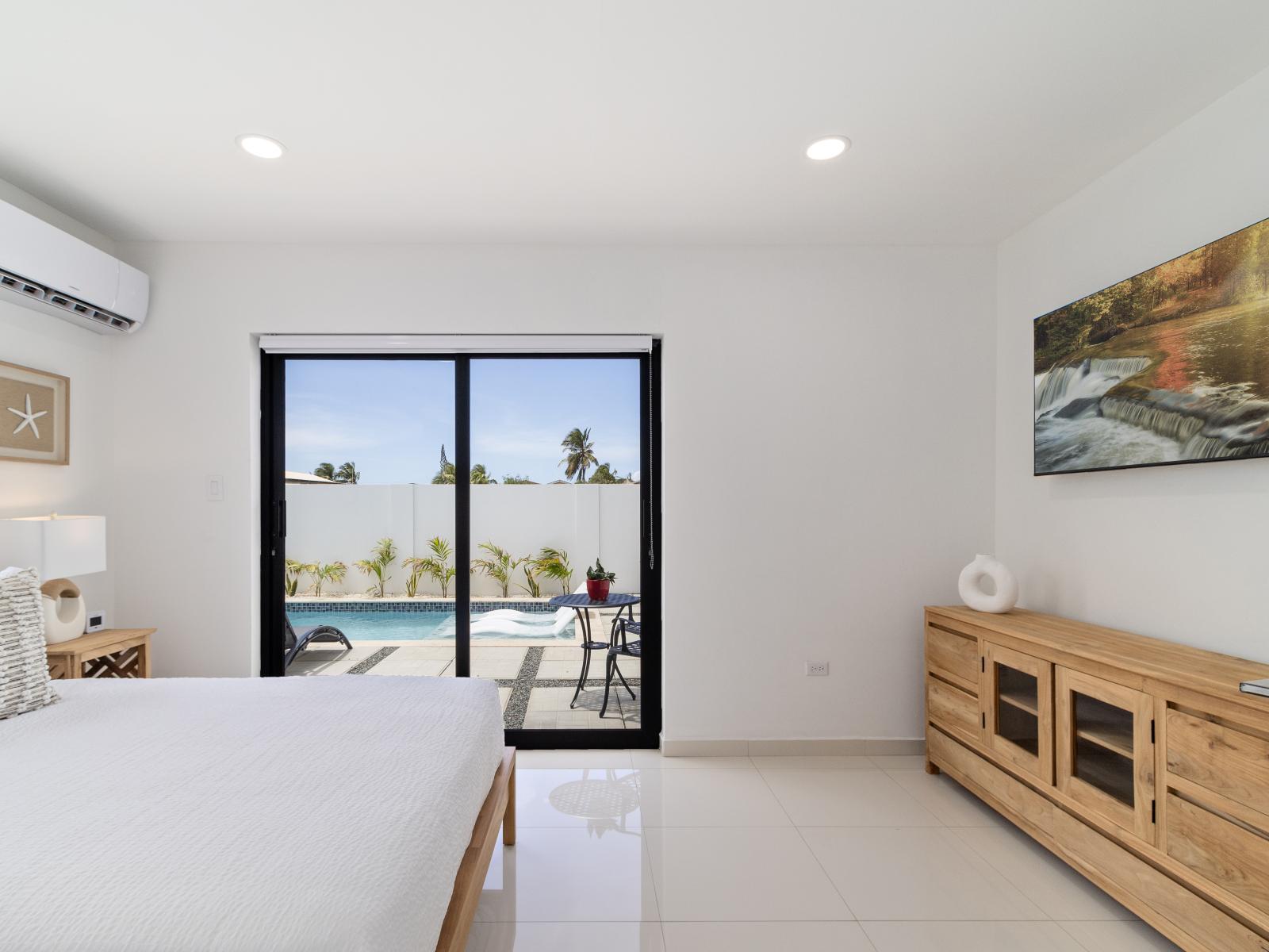 Enchanting bedroom of the home in Oranjested Aruba - Glass sliding doors that open into the backyard  - Smart TV for entertainment - Harmonious color palette creating a soothing atmosphere