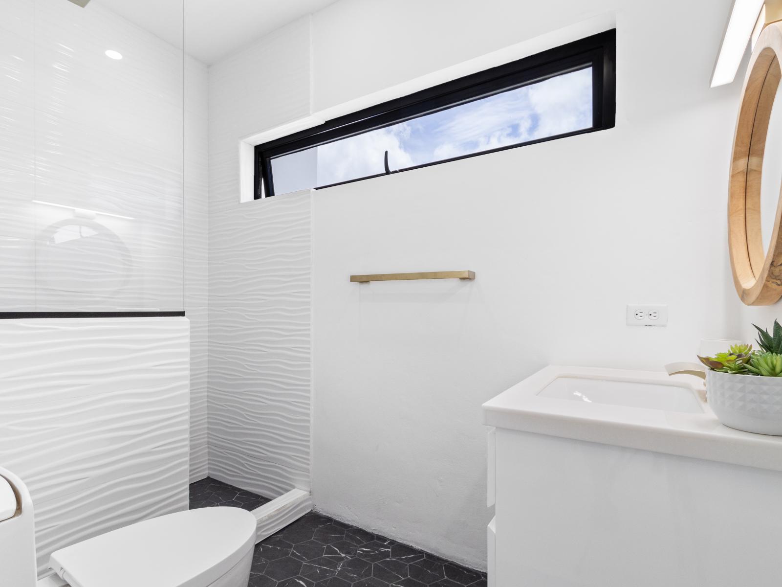 Polished bathroom of the home in Oranjestad Aruba - Beautiful vanity with beautiful mirror - Availability of all bathroom amenities - Spacious shower area