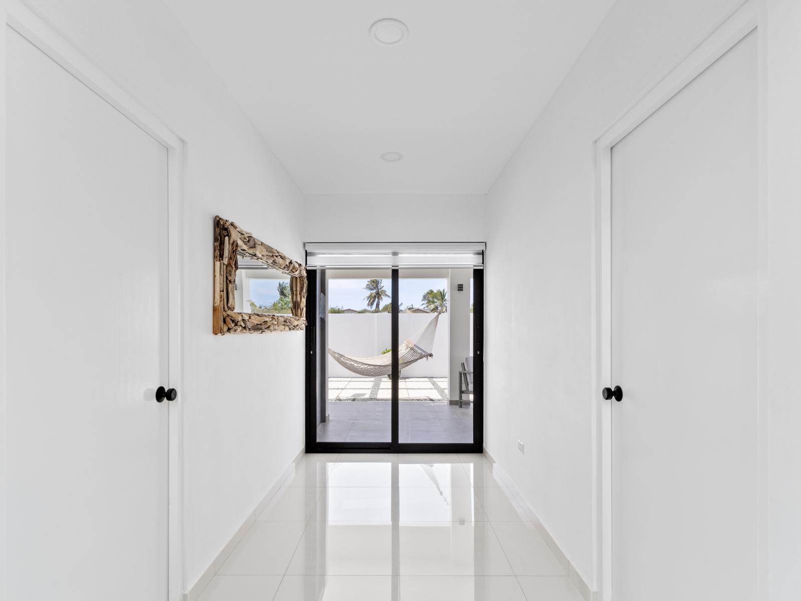 Hallway to the backyard of the home in Oranjestad Aruba - Experience the calmness of our hallway leading to outdoor oasis - Experience the anticipation of rest as you journey down our welcoming hallway