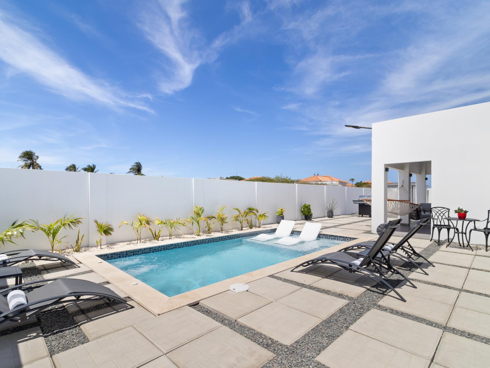 Stunning private pool of the home in Oranjestad Aruba - Lots of chairs by the pool for laying in the sun - Experience paradise at pool oasis - Sparkling waters that beckon you to dive in and unwind