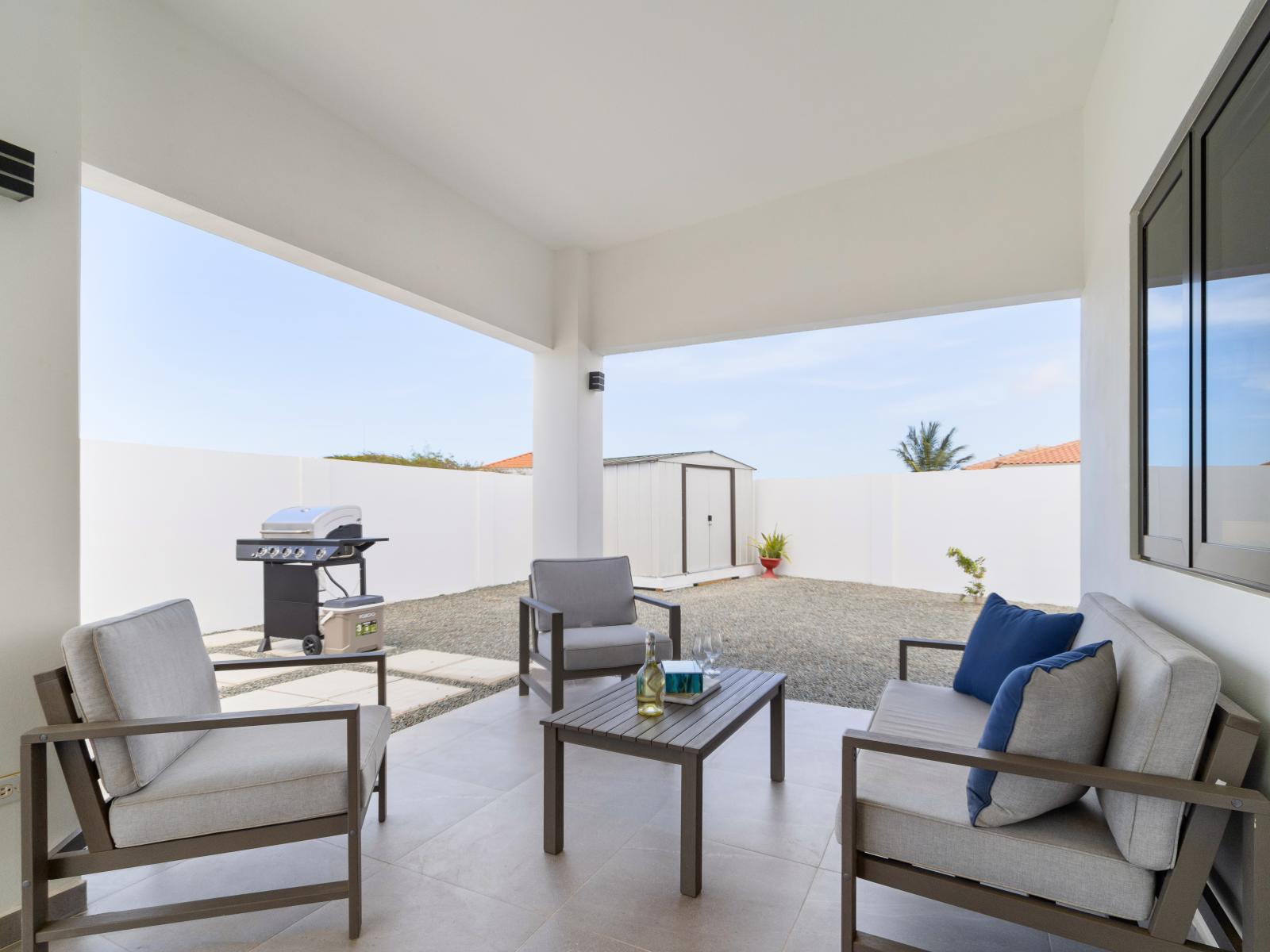 Shaded outdoor seating area of the home in Oranjestad Aruba - Cozy outdoor retreat with seating - Private oasis with a sense of tranquility - BBQ grill