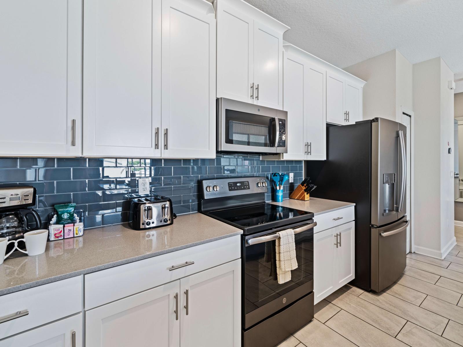 Full equipped kitchen of the townhouse in Kissimmee Florida - Thoughtful placement of kitchen essentials for easy access - Elegant and coordinated color palette for a cohesive look - Breakfast bar for additional workspace